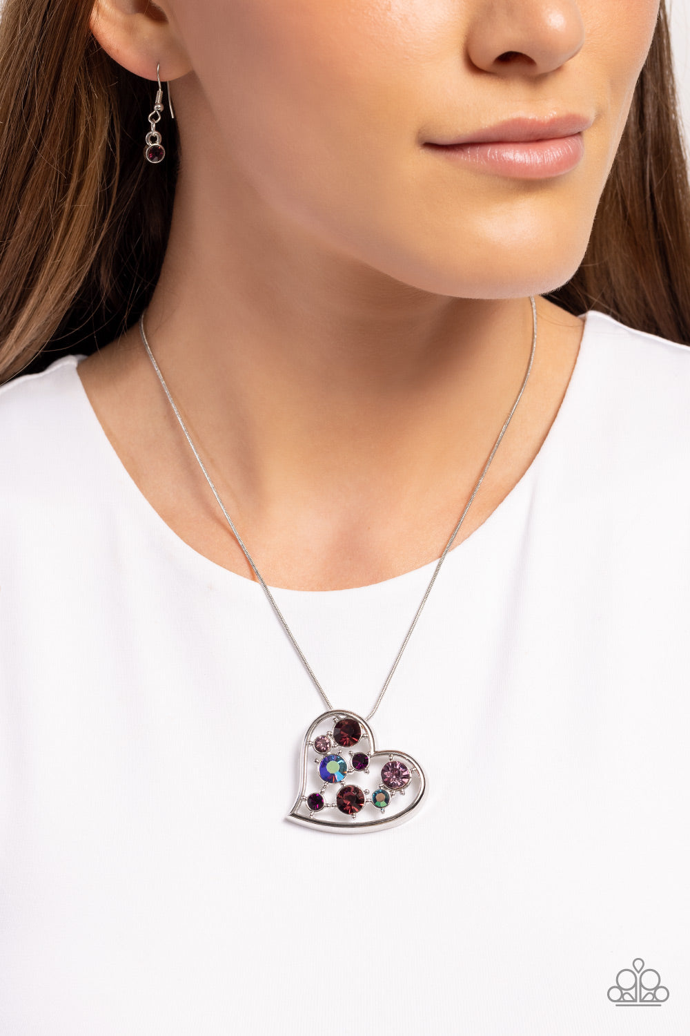 Paparazzi Accessories Romantic Recognition - Purple Cascading from a silver snake chain, a thick, sideways sliding-heart silhouette falls down the neckline for a romantic statement. Haphazardly scattered across the inside of the heart frame, a glittery co