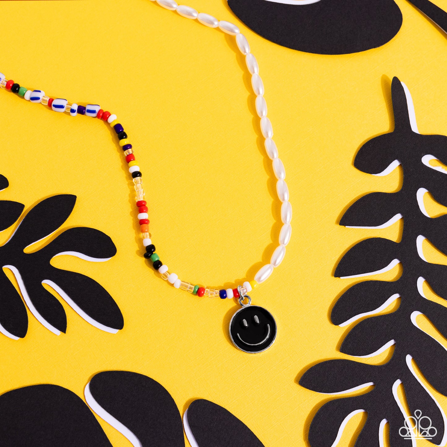 Paparazzi Accessories Smiling Showdown - Black A strand of gleaming half pearl beads combines with seed beads in colorful shades for a youthful design along the collar. A black smiley face disc hangs from the colorfully classic display for additional char