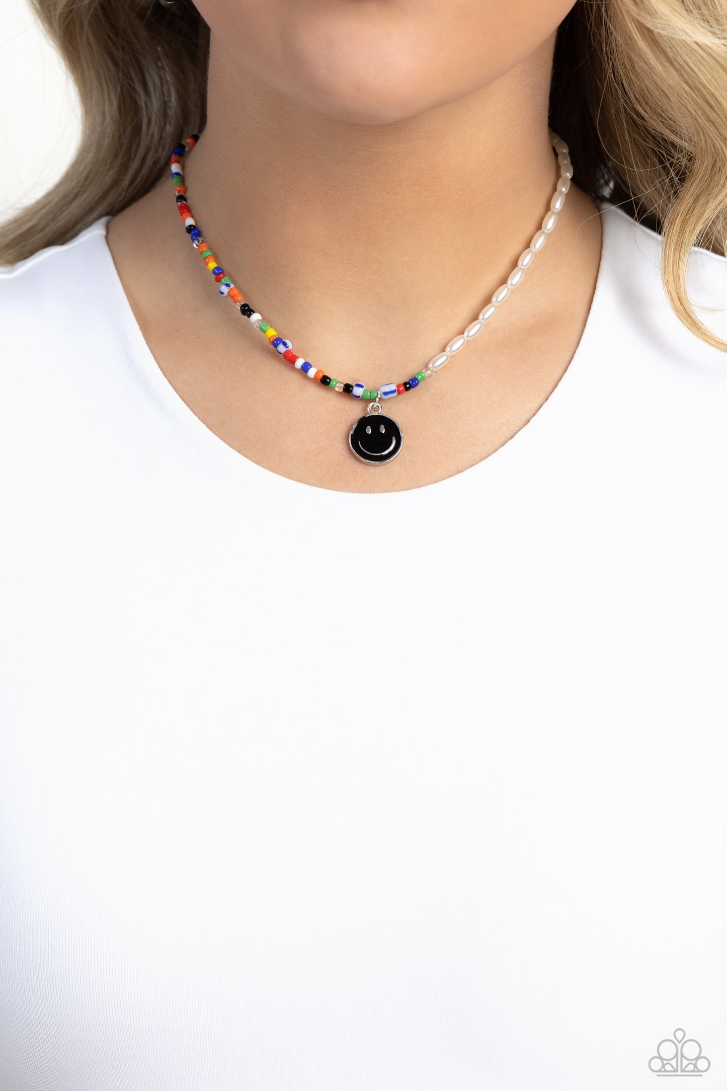 Paparazzi Accessories Smiling Showdown - Black A strand of gleaming half pearl beads combines with seed beads in colorful shades for a youthful design along the collar. A black smiley face disc hangs from the colorfully classic display for additional char