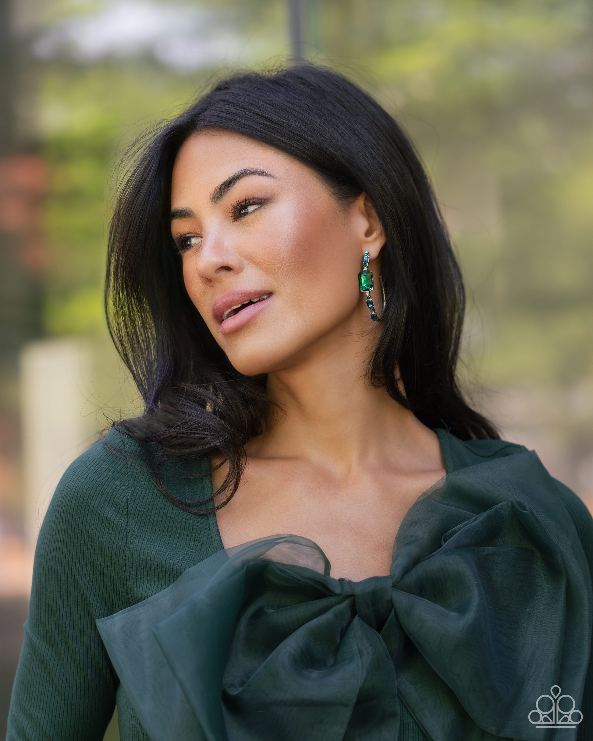 Paparazzi Accessories Elite Ensemble - Green Encrusted in round and emerald-cut aquamarine and emerald gems, some featuring an iridescent sheen, an exaggerated oblong silver hoop curls around the ear, refracting light in a dramatic, knockout finish. Earri