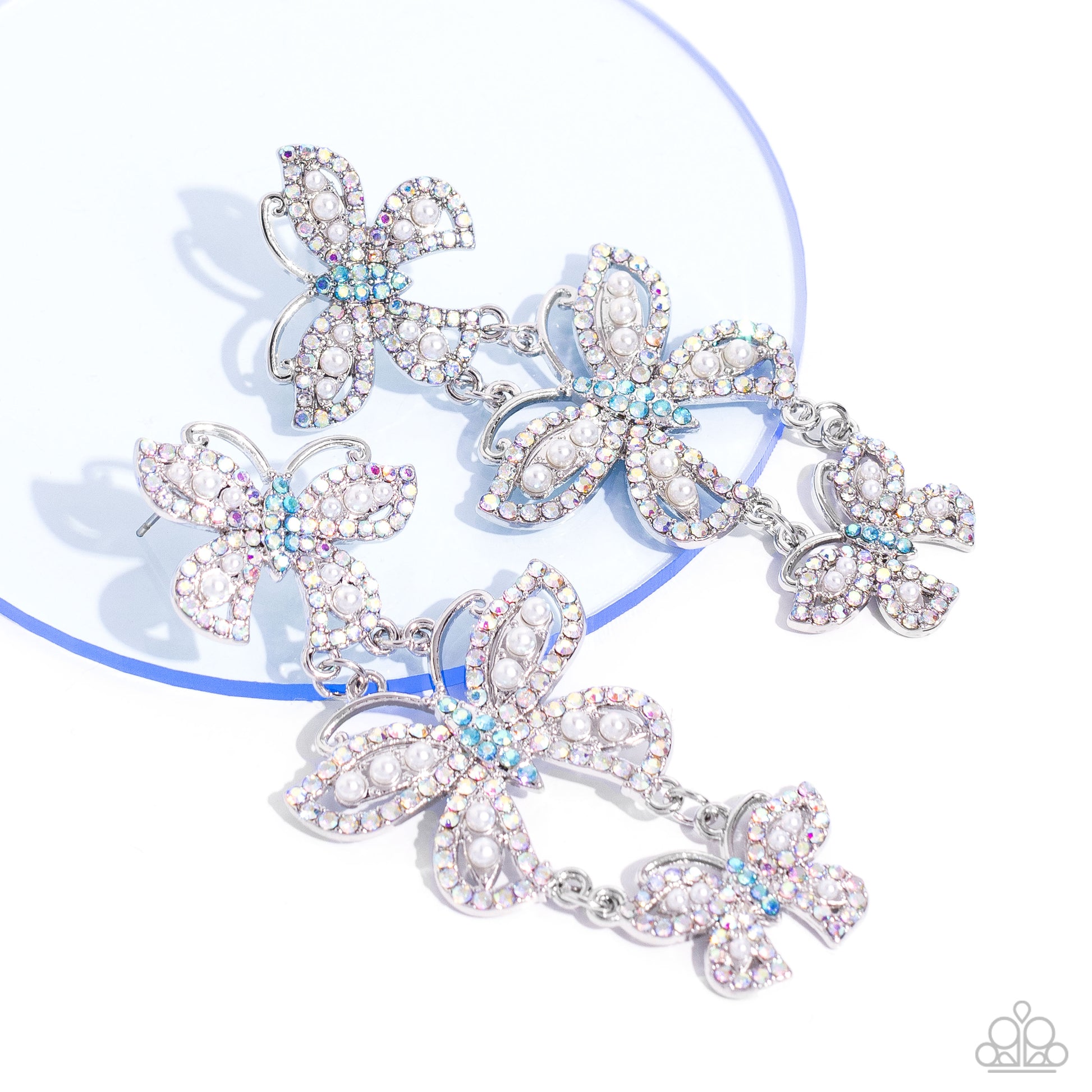 Paparazzi Accessories Fluttering Finale - Multi An airy trio of silver butterflies of various sizes link into a whimsical lure. Each butterfly's wings have been dipped in iridescent rhinestones and white pearls, while the bodies are dipped in blue iridesc