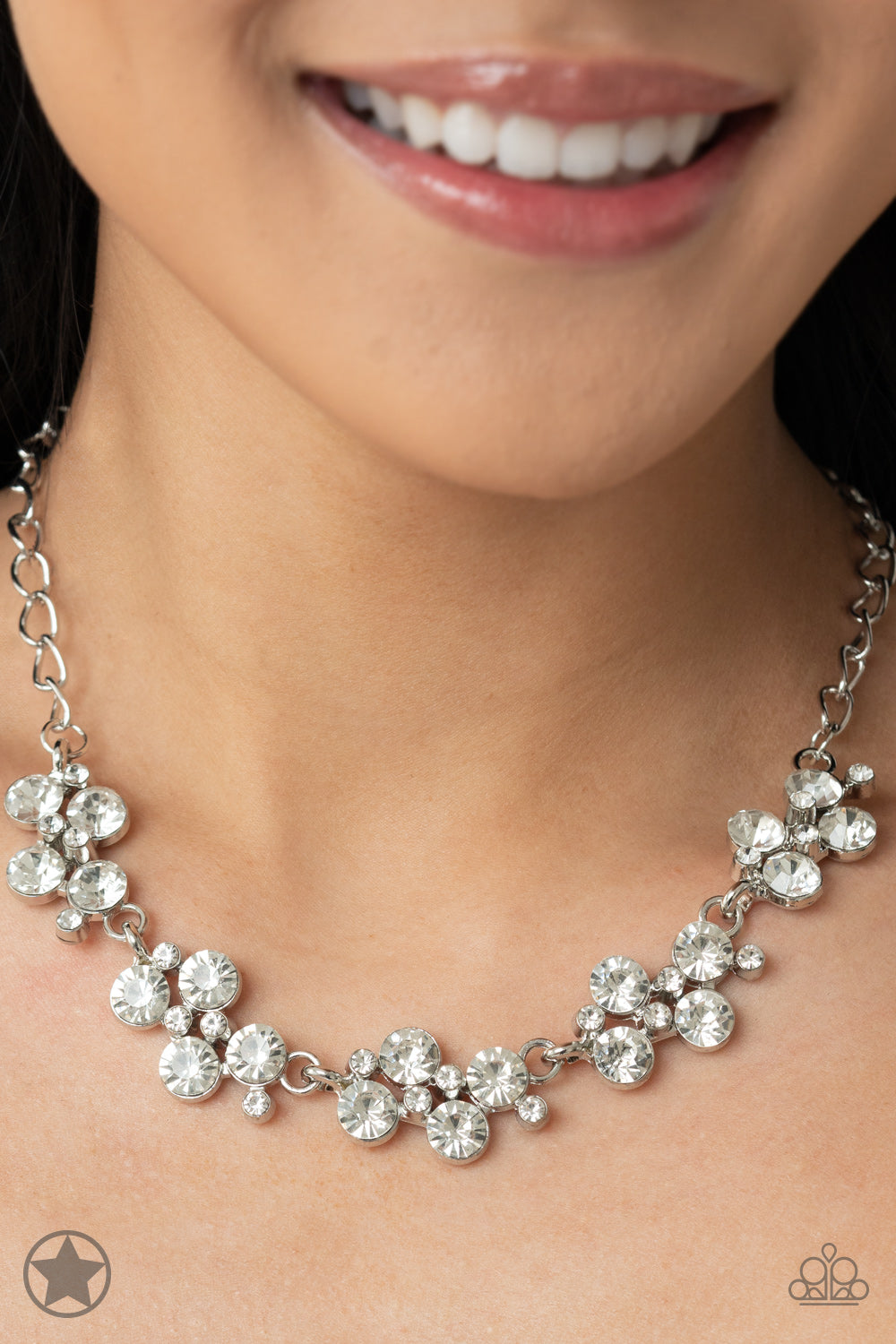Paparazzi Accessories Hollywood Hills - White A row of dazzling white rhinestones drapes along the neckline, creating a sparkling display. Daintier white rhinestones are sprinkled along the clusters, adding luminous detail to the timeless design. Features
