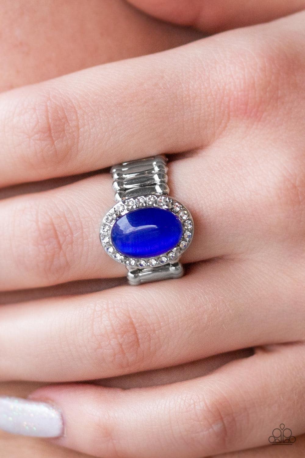 Paparazzi Accessories Laguna Luxury - Blue A majestic Princess Blue moonstone is pressed into the center of a silver frame radiating in glassy white rhinestones for timeless finish. Features a stretchy band for a flexible fit. Jewelry