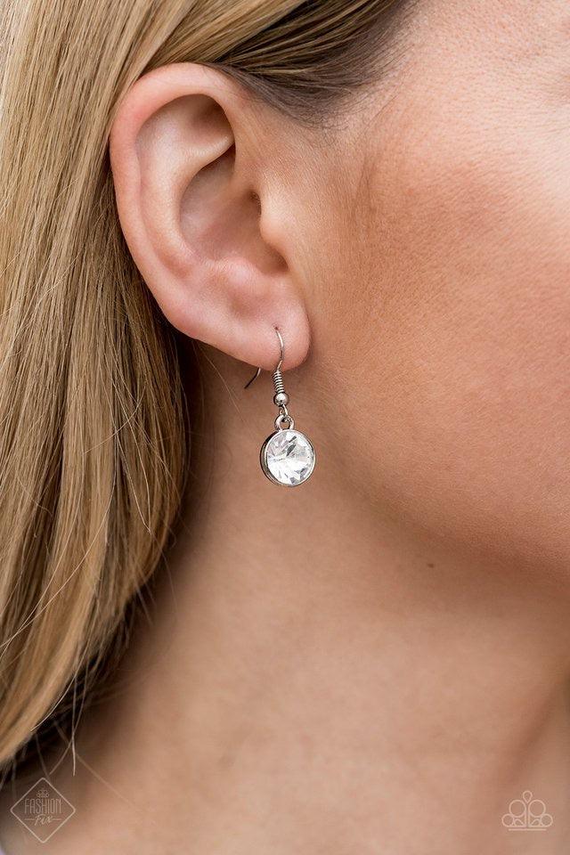 Paparazzi Accessories Inner Light - White A collection of glassy white rhinestone encrusted frames link below the collar in a timeless fashion. A matching rhinestone encrusted frame and oversized white gem dangle from the bottom, creating a glamorous exte
