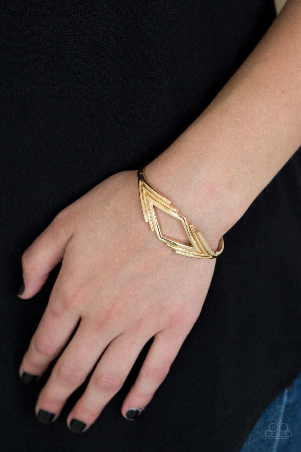 Paparazzi Accessories In Total De-NILE - Gold Brushed in a high-sheen finish, glistening V-shaped frames join into a dainty cuff. The airy center allows the skin to peek beneath the geometric frame for a natural finish. Jewelry