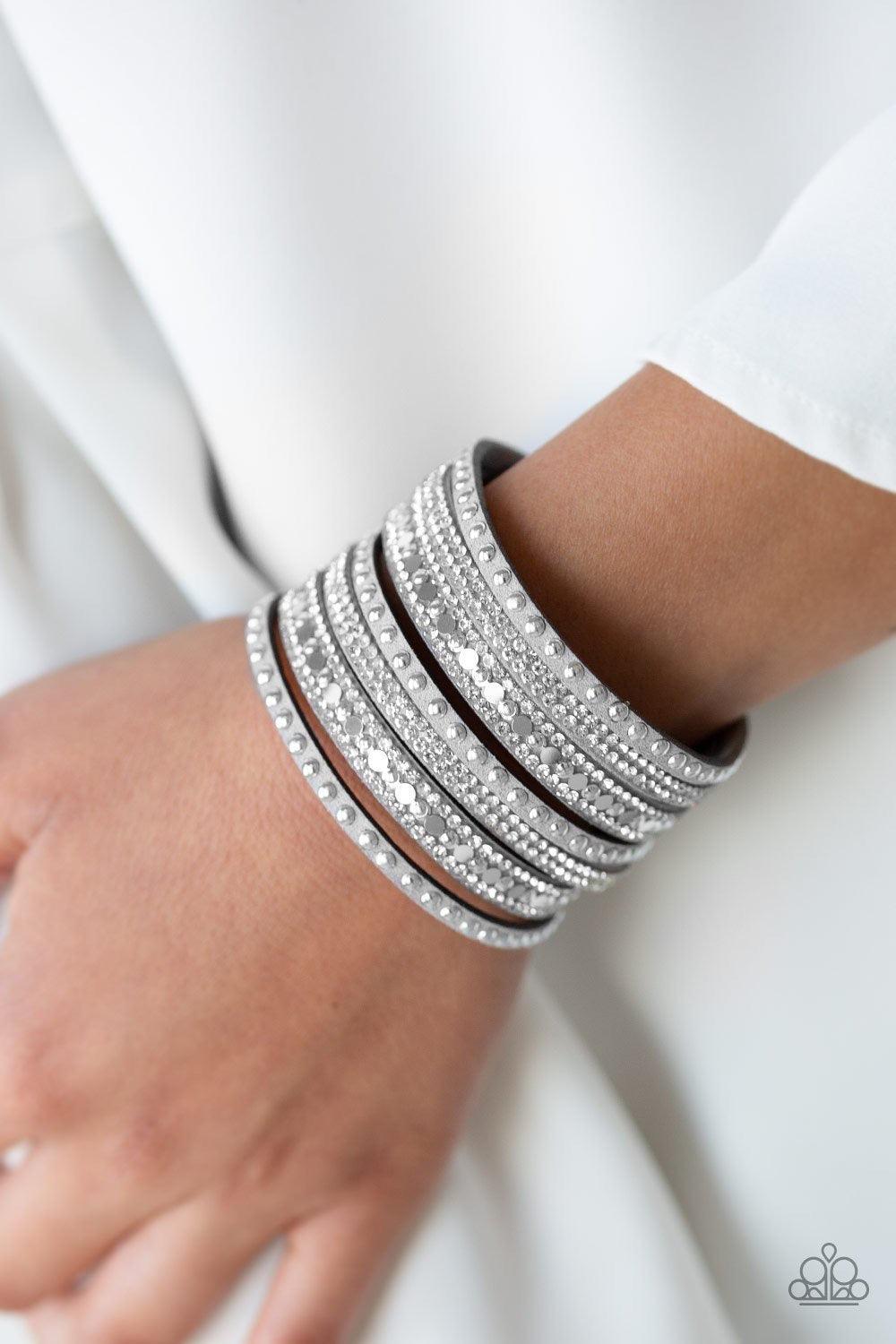 Paparazzi Accessories All Hustle And Hairspray - Silver A thick gray suede band has been spliced into glittery strands encrusted in a collection of dainty silver studs, glittery white rhinestones, and flat silver sequins for a sassy look. Features an adju