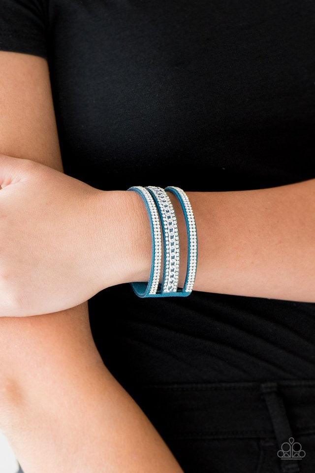 Paparazzi Accessories Rollin In Rhinestones - Blue Rows of glassy white rhinestones and a shimmery silver chain are encrusted along blue suede bands for a sassy look. Features an adjustable snap closure. Sold as one individual bracelet. Jewelry