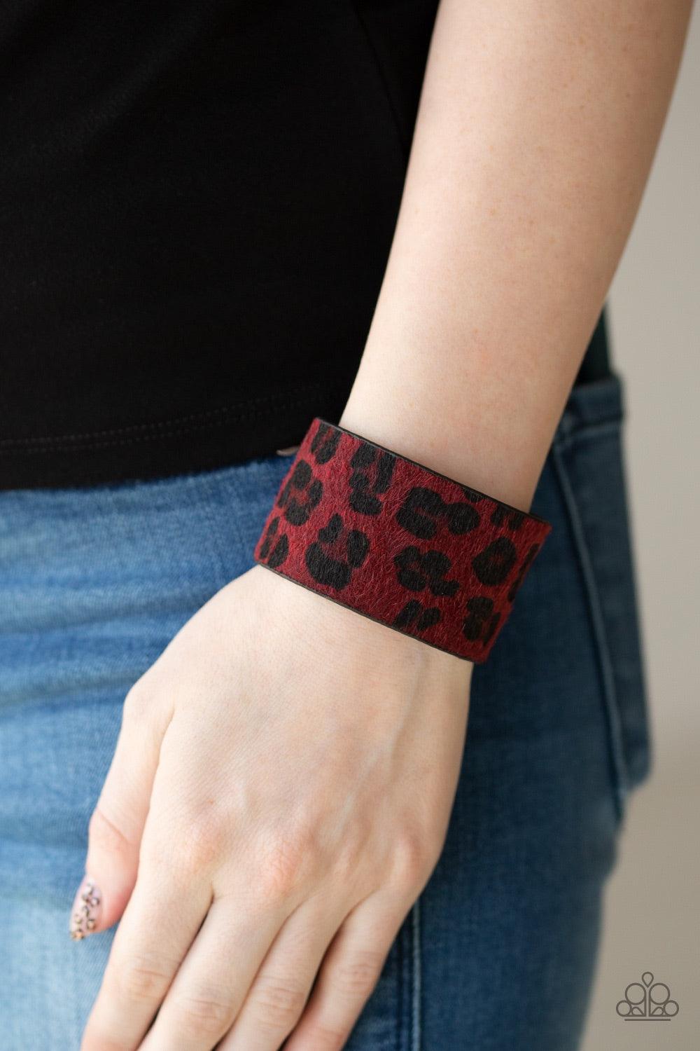 Paparazzi Accessories Cheetah Cabana - Red A fuzzy red cheetah pattern is printed across the front of a thick black leather band for a wild look. Features an adjustable snap closure. Jewelry
