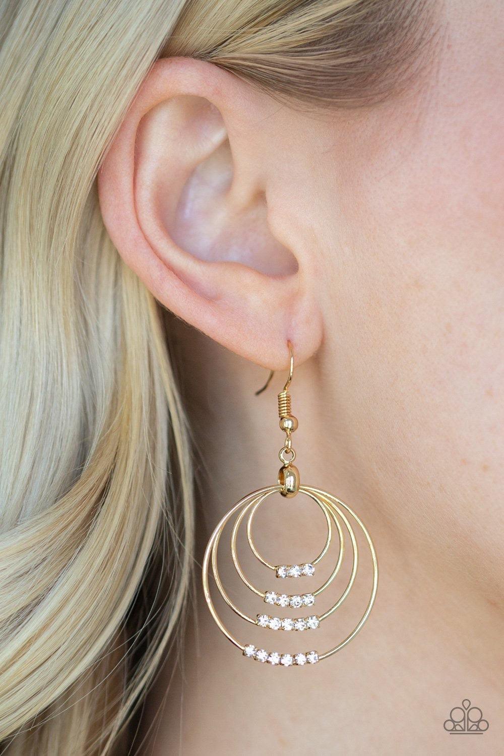 Paparazzi Accessories Sparkle Spectrum - Gold The bottoms of dainty gold hoops are encrusted in rows of glassy white rhinestones as the frames ripple from the ear, coalescing into a dizzying lure. Earring attaches to a standard fishhook fitting. Jewelry