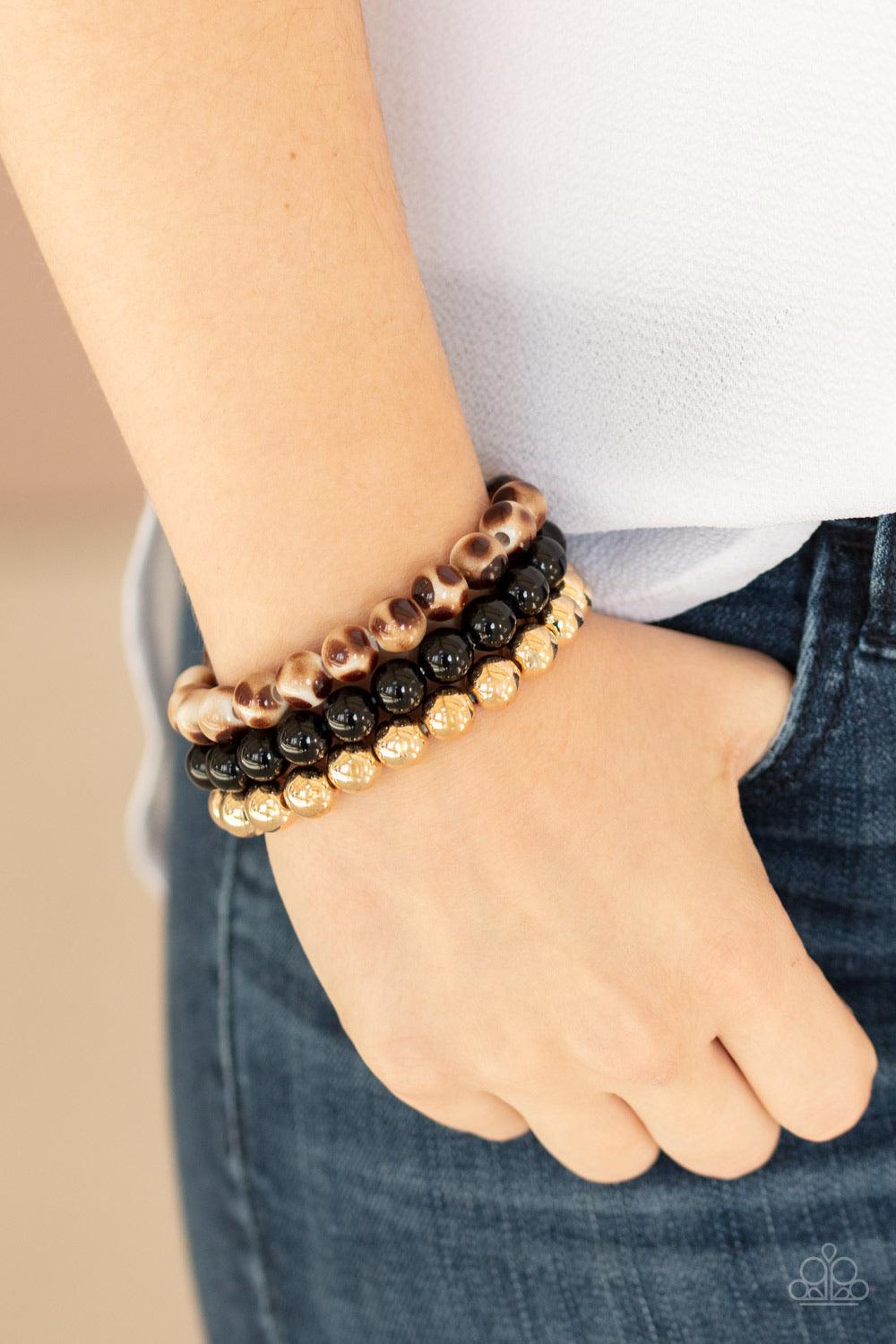Paparazzi Accessories Courageously Couture - Black Strands of black, gold, and brown tortoise-like beads are threaded along stretchy bands around the wrist, creating colorful layers. Jewelry
