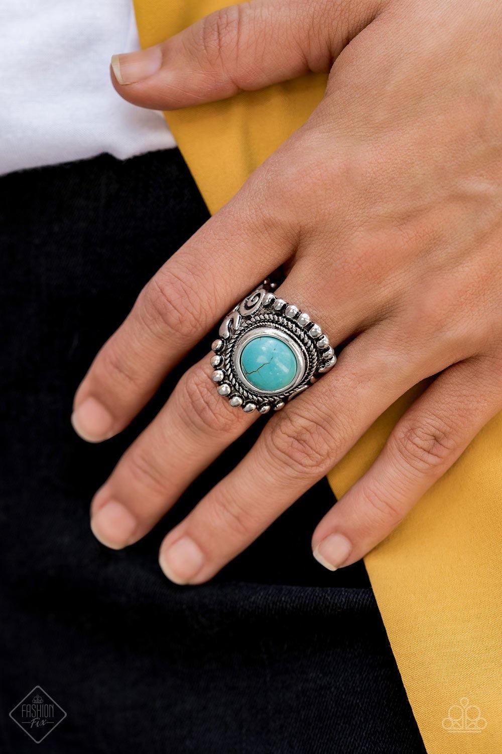 Paparazzi Accessories Nomad Drama - Blue A refreshing turquoise stone is pressed into the center of a round silver frame bordered by shiny silver studs for a rustic look. Features a stretchy band for a flexible fit. Jewelry