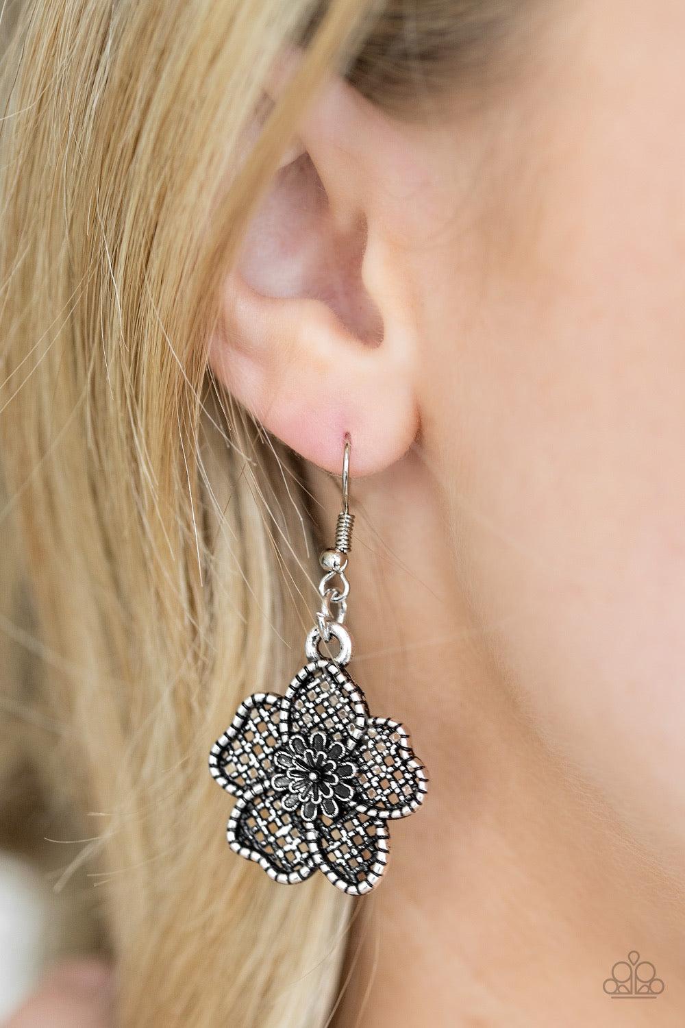 Paparazzi Accessories Petunia Paradise - Silver Featuring lattice-like patterns, shimmery silver flowers bloom below the collar for a seasonal look. Features an adjustable clasp closure. Sold as one individual necklace. Includes one pair of matching earri