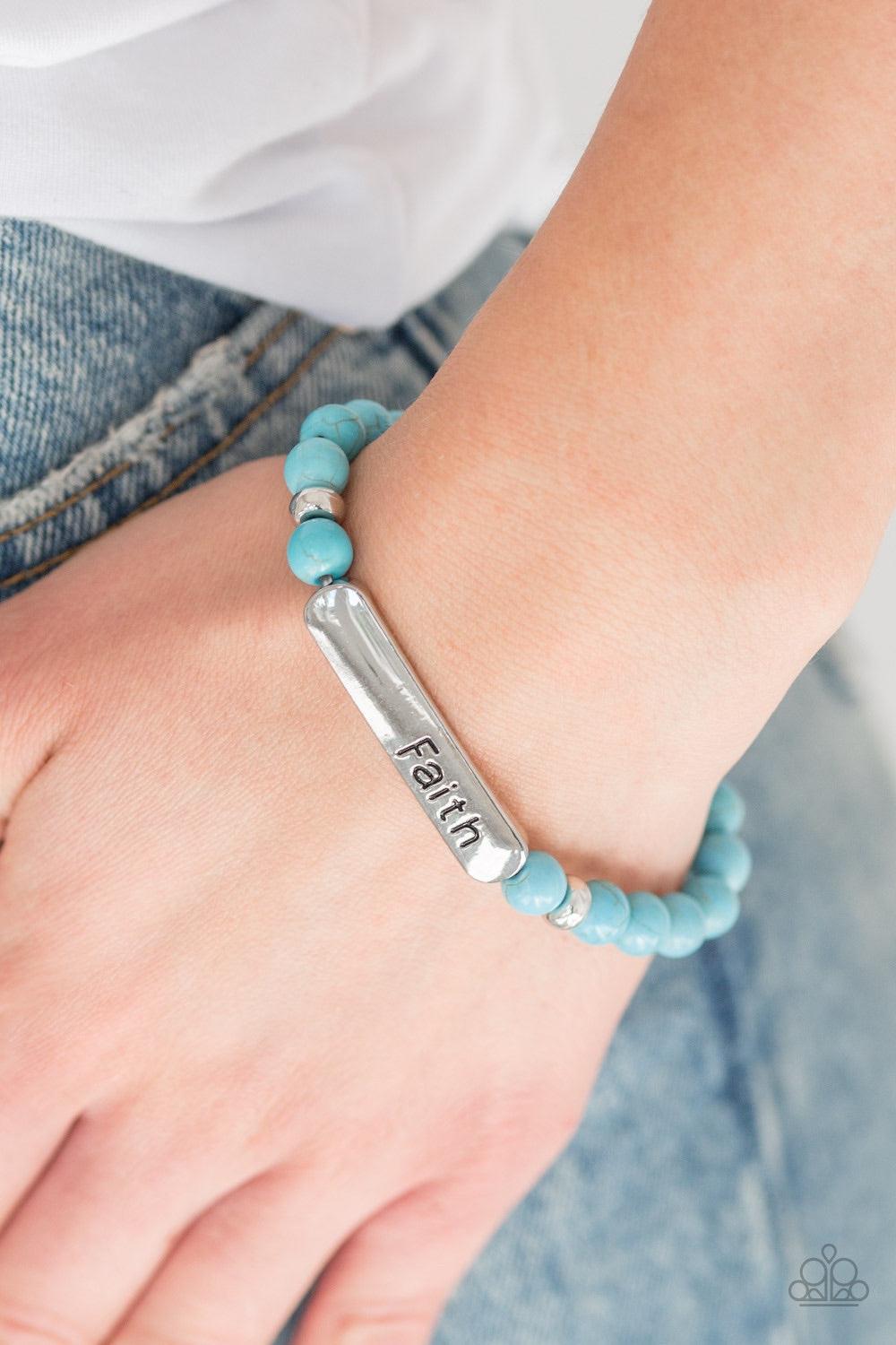 Paparazzi Accessories Fearless Faith - Blue Infused with dainty silver beads, refreshing turquoise stone beads and a glistening silver plate stamped in the word, "Faith" are threaded along a stretchy band for a seasonal look. Jewelry
