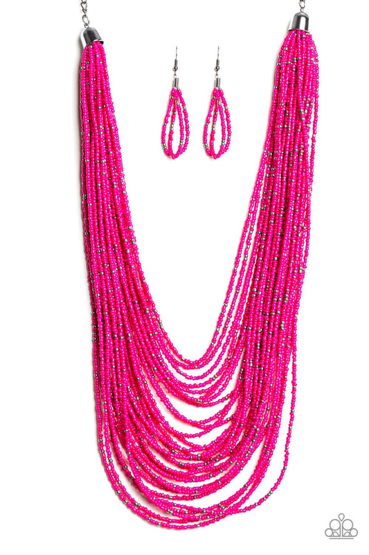 Paparazzi Accessories Rio Rainforest - Pink Suspended between two gunmetal fittings, row after row of countless strands of Pink Peacock seed beads layer below the collar. Dainty gunmetal seed beads are sprinkled across the strands for a seasonal finish. F