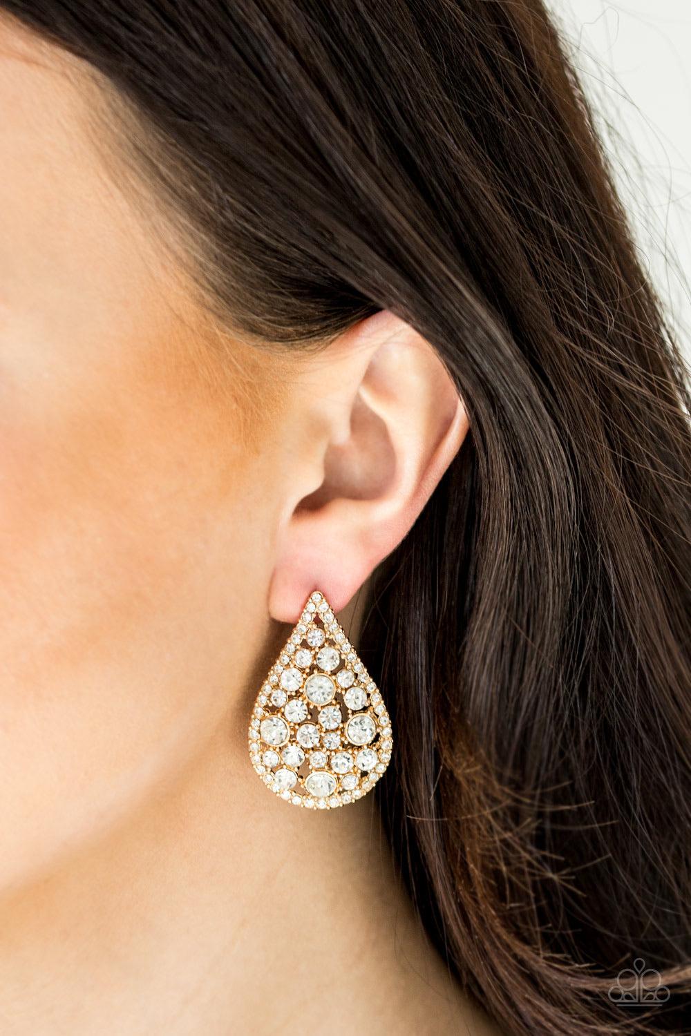 Paparazzi Accessories REIGN Storm - Gold Radiating with glassy white rhinestones, oversized gold teardrops adorn the ear for a dramatic flair. Earring attaches to a standard post fitting. Jewelry