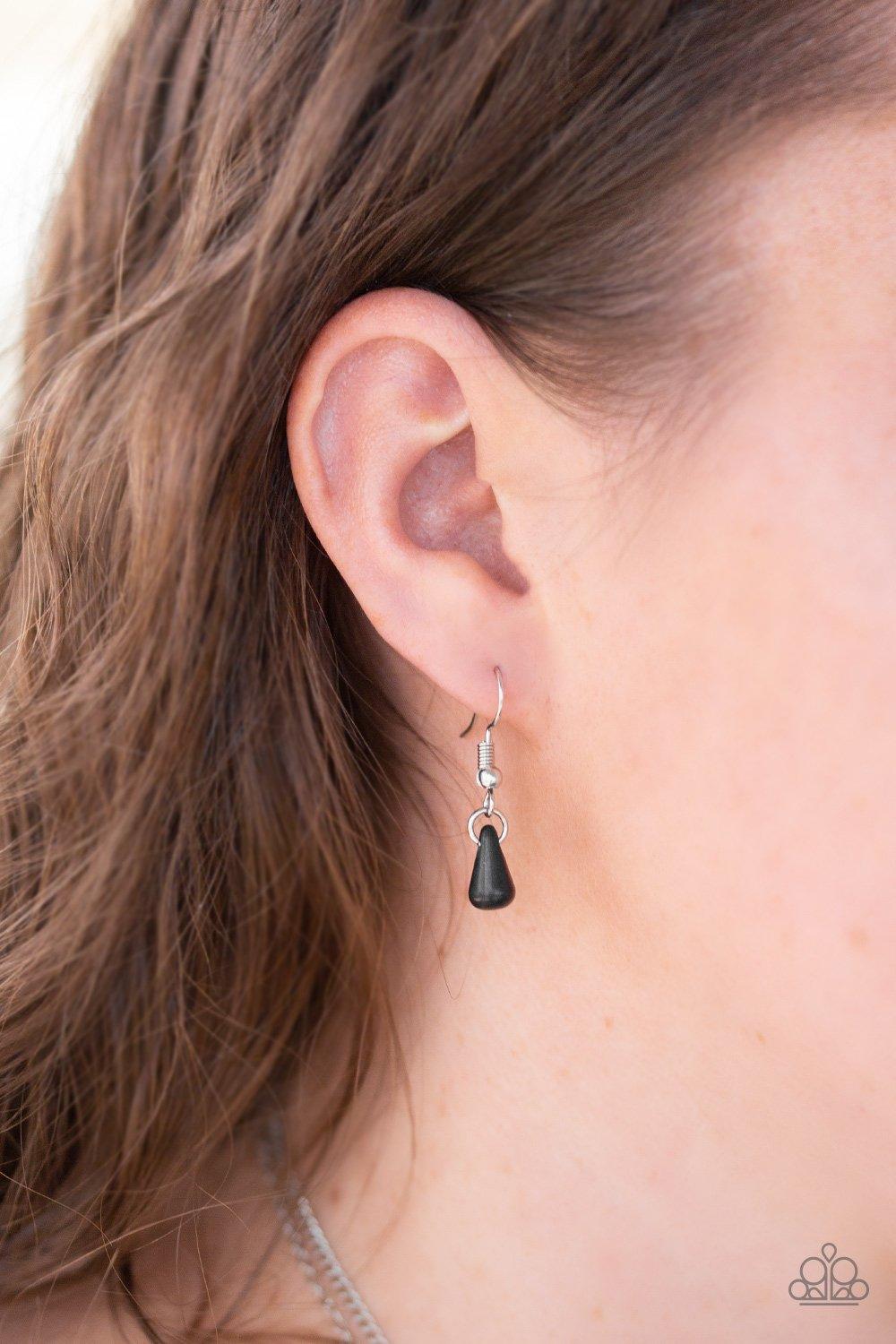 Paparazzi Accessories Gypsy Go-Getter - Black Radiating with linear patterns, a shimmery silver frame swings from the uppermost chain above a silver disc radiating with floral detail. A dainty black bead dots the center of the lowermost pendant for a colo