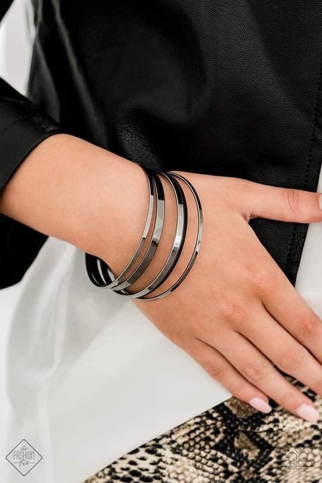 Paparazzi Accessories Ensnared - Black A collection of flat gunmetal bangles stack along the wrist, creating an irresistible edgy shimmer. Jewelry