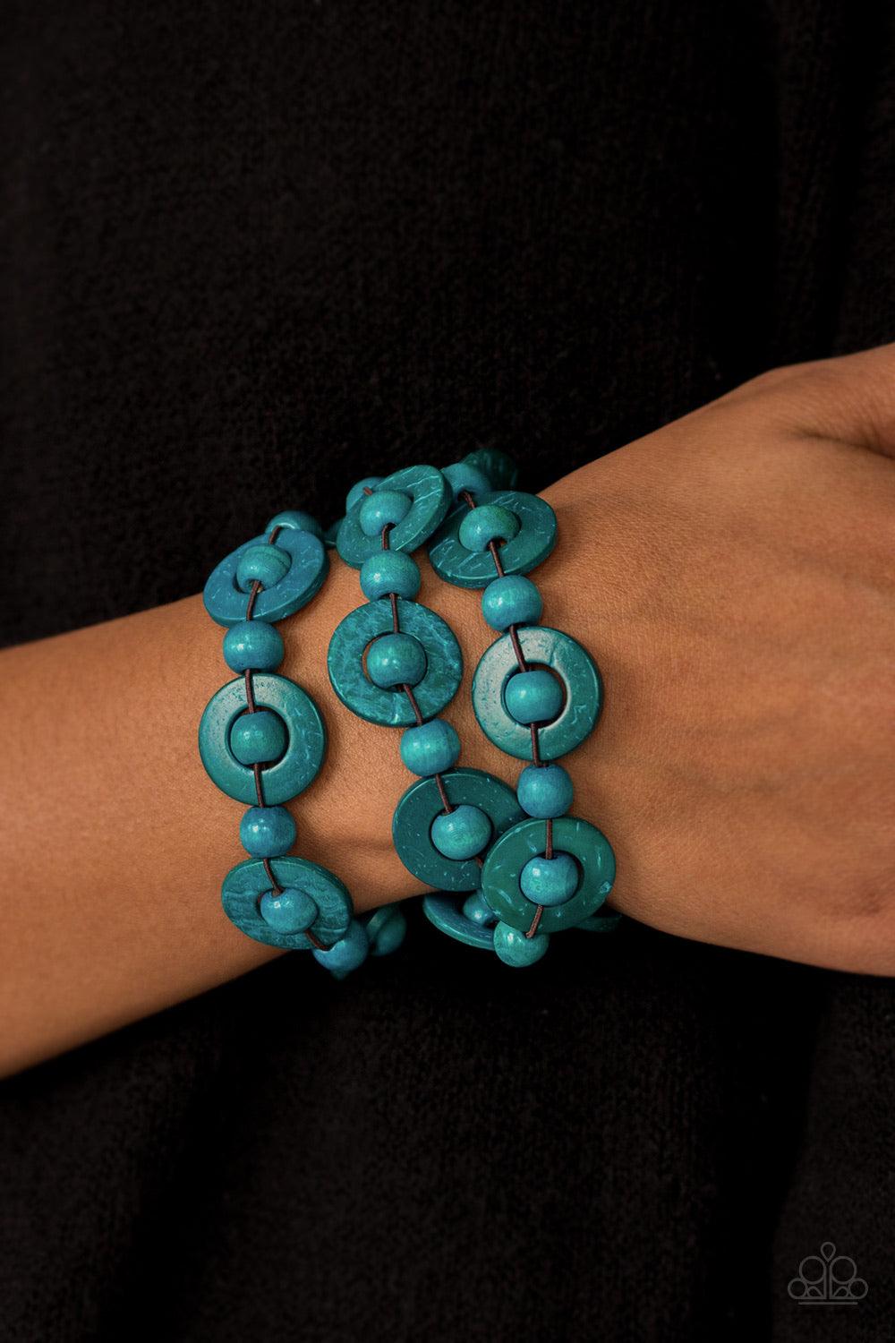 Paparazzi Accessories Cancun Catch ~Blue Brushed in refreshing blue finishes, wooden rings and beads are knotted in place along three stretchy strands, creating summery layers around the wrist. Features a button loop closure. Sold as one individual bracel