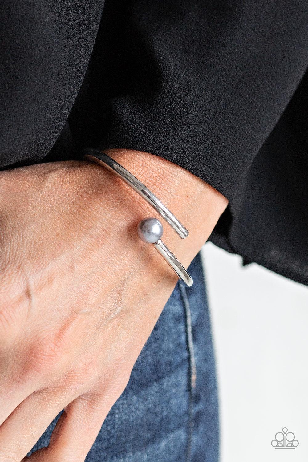 Paparazzi Accessories Industrial Impact - Silver Featuring a solitaire silver pearl, two shiny silver bars attach to a spring-like fitting as they curl around the wrist for a modern finish. Jewelry