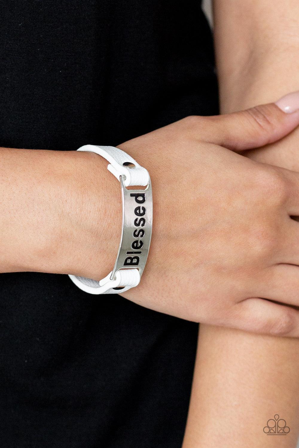 Paparazzi Accessories Count Your Blessings - White Stamped in the word, "Blessed", a shiny silver plate is studded in place along a dainty white leather band for a whimsical look. Features an adjustable snap closure. Jewelry