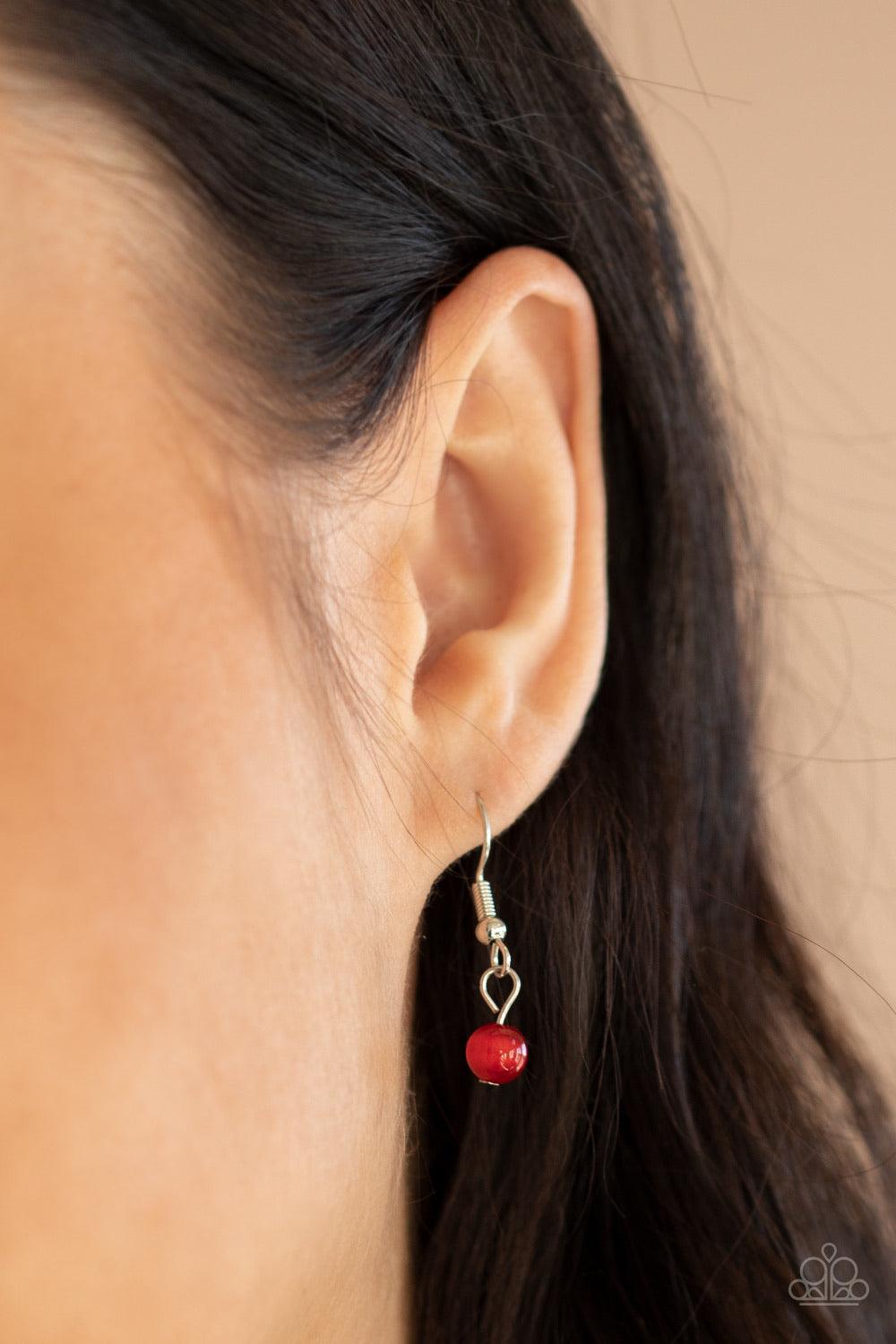 Paparazzi Accessories A Dream Is A Wish Your Heart Makes - Red Featuring a red cat's eye stone center, a glistening silver locket inspired frame glides along a dainty silver chain below the collar for a charming look. Sections of dainty white rhinestones