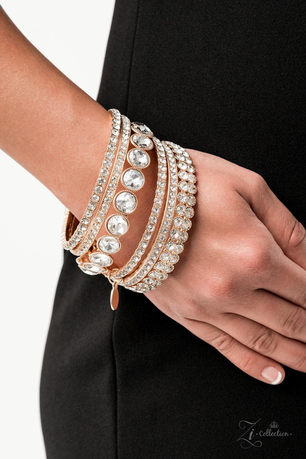 Paparazzi Accessories Future Fashionista An oversized collection of glittery white rhinestones are encrusted across the front of elegantly mismatched gold bangles. The blinding collection stacks and slides across the wrist, creating spellbinding sparkle w