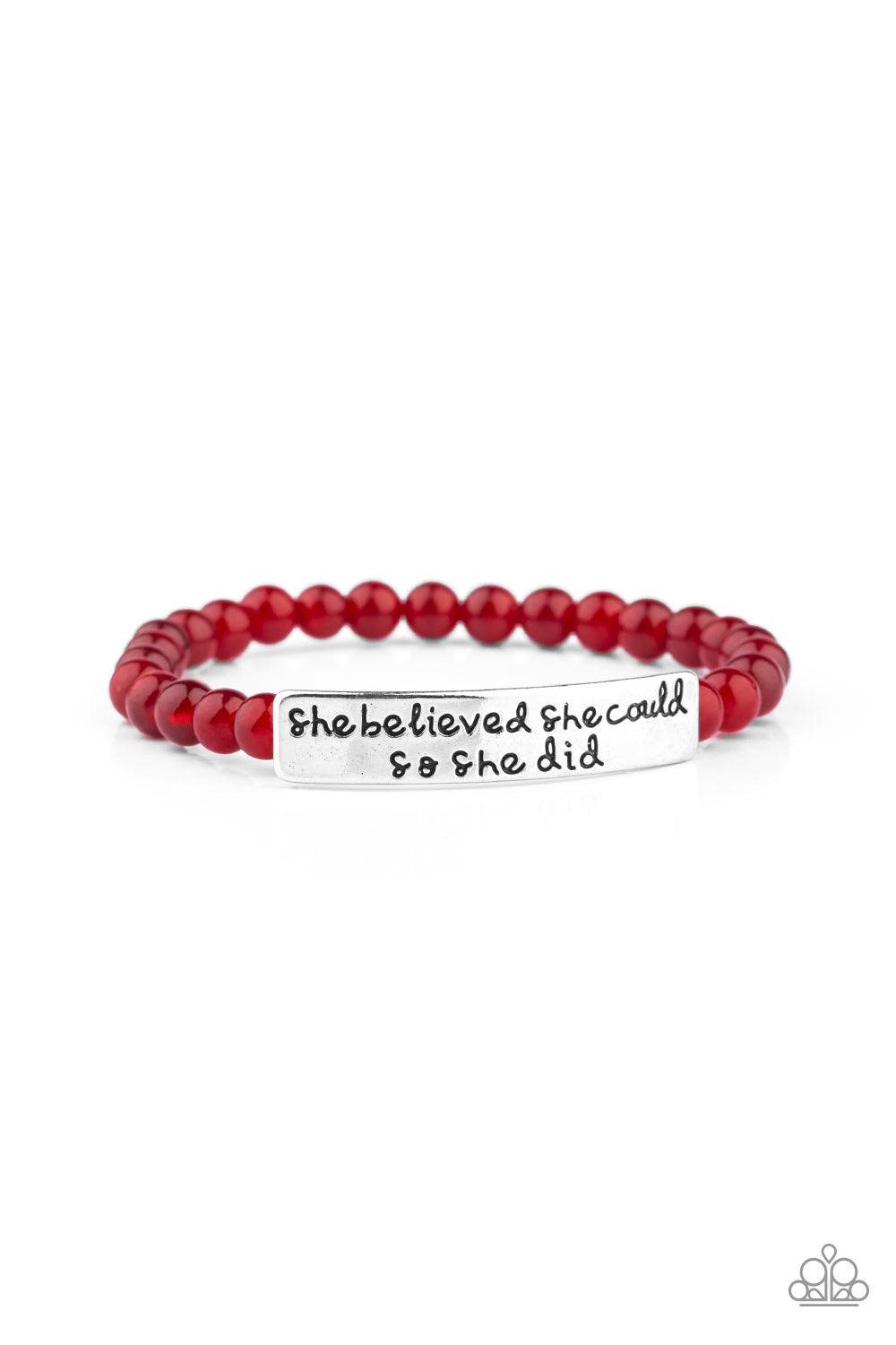 Paparazzi Accessories So She Did - Red A collection of dainty red cat’s eye stone beads and an antiqued frame stamped in the inspirational phrase, “She believed she could, so she did”, are threaded along a stretchy band around the wrist for a whimsical fa