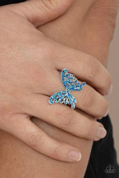 Paparazzi Accessories Butterfly Orchard - Blue Featuring an iridescent shimmer, dainty blue rhinestones adorn a silver butterfly atop the finger for an enchanted fashion. Features a stretchy band for a flexible fit. Jewelry