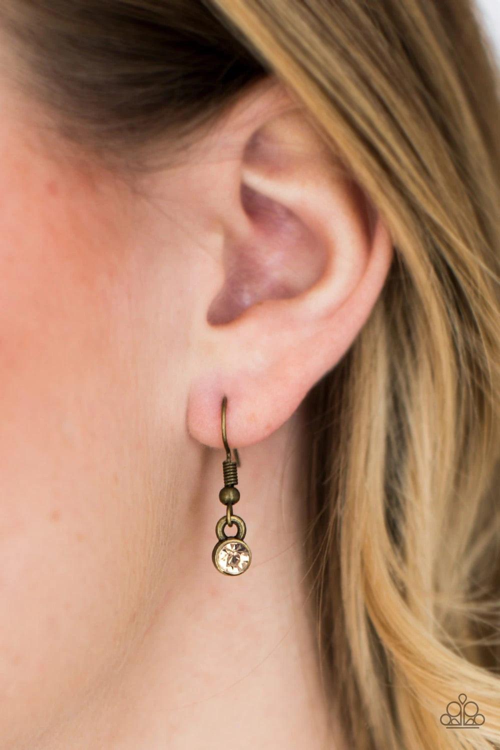 Paparazzi Accessories Step Into The Spotlight - Brass Infused with an elegantly elongated brass chain, a topaz rhinestone encrusted teardrop interlocks with a smooth brass teardrop, creating a refined pendant. Features an adjustable clasp closure. Sold as