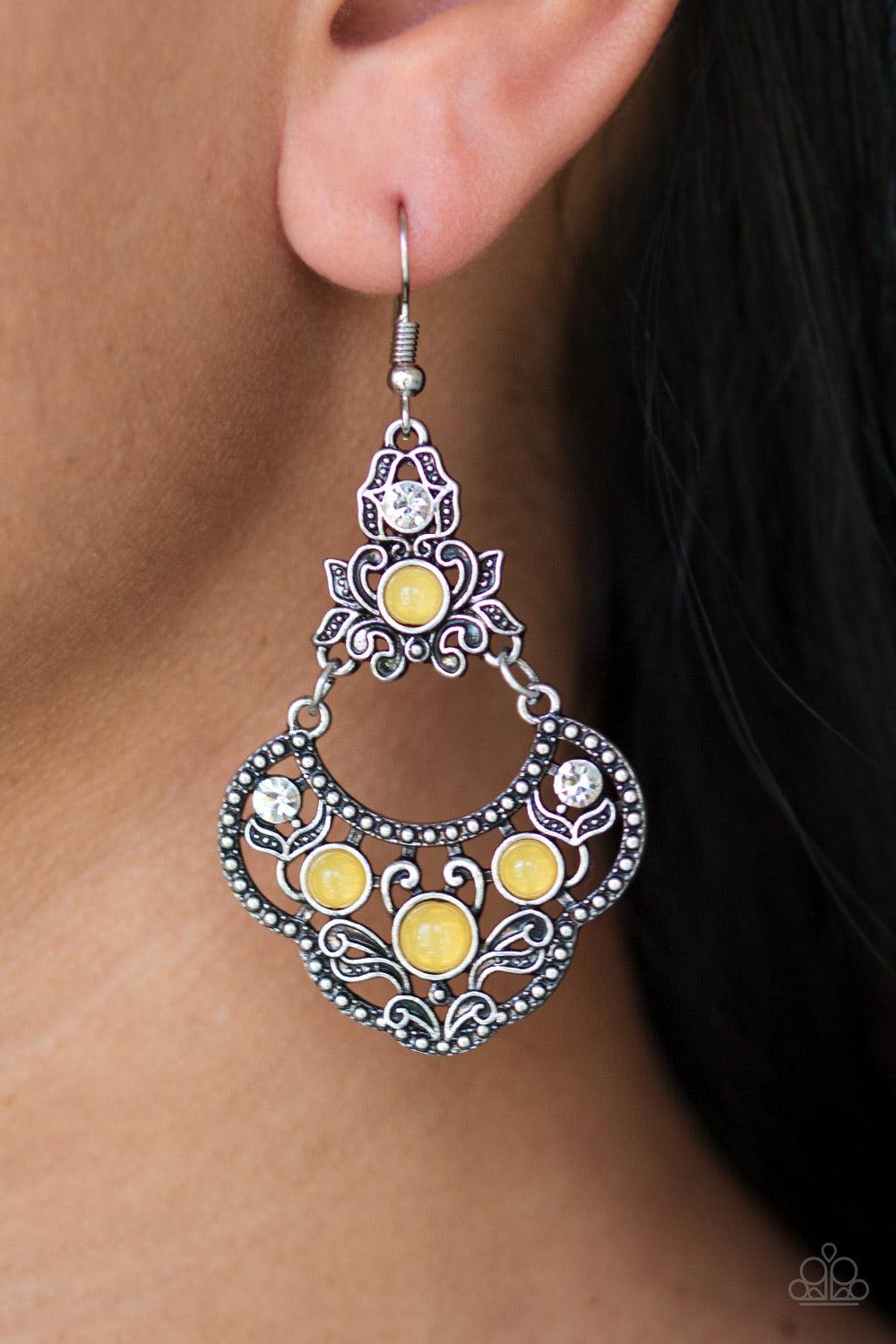 Paparazzi Accessories Garden State Glow - Yellow Glowing yellow beads and glittery white rhinestones are sprinkled along an ornate silver frame radiating with leafy filigree for a whimsical look. Earring attaches to a standard fishhook fitting. Sold as on
