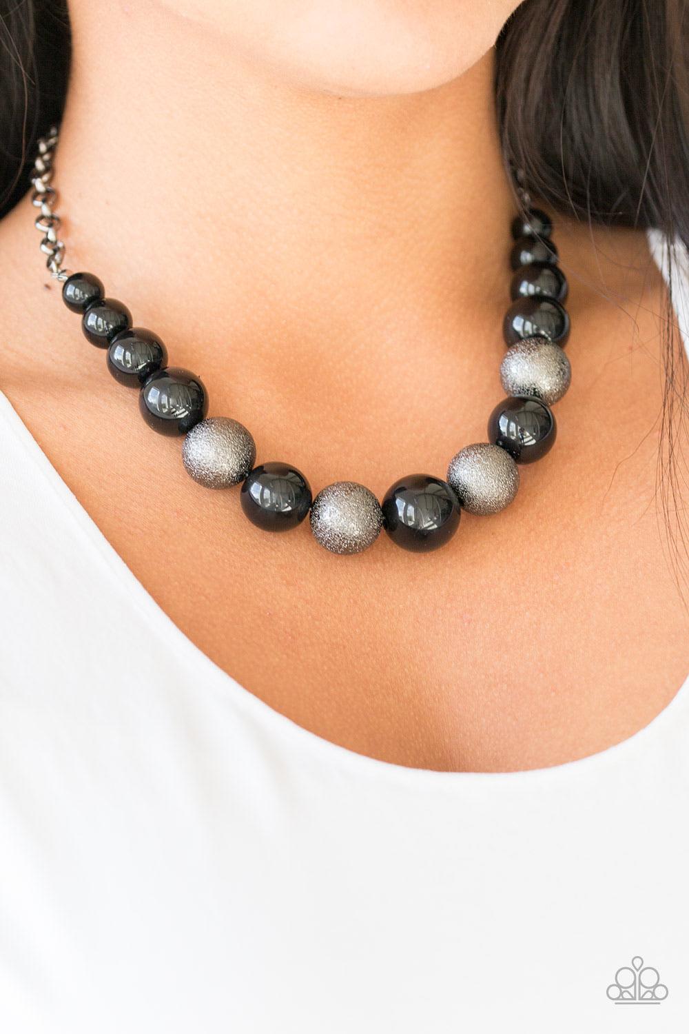 Paparazzi Accessories Color Me CEO - Black Dusted in glitter, sparkling gunmetal and shiny black beads are threaded along an invisible wire below the collar for a glamorous look. Features an adjustable clasp closure. Sold as one individual necklace. Inclu