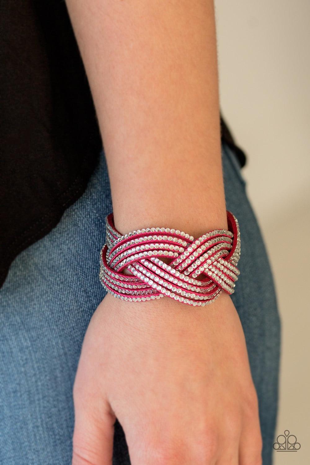 Paparazzi Accessories Big City Shimmer - Pink Glassy white rhinestones are encrusted along crisscrossing strands of pink suede, creating bold shimmer around the wrist. Features an adjustable snap closure. Jewelry