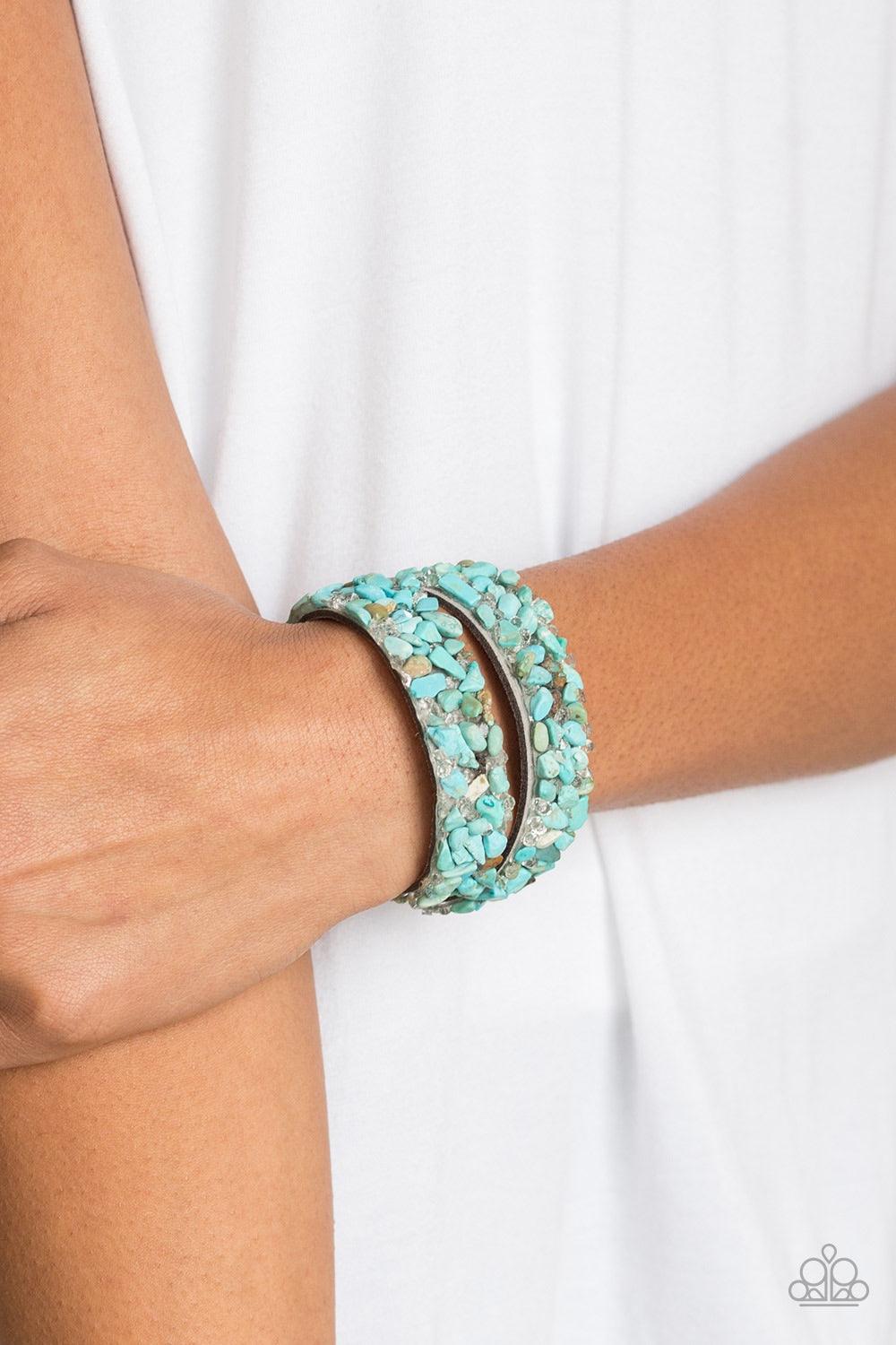 Paparazzi Accessories Crush to Conclusions - Blue A collection of crushed turquoise rocks and glassy white rhinestone prisms are sprinkled across a gray suede band for a seasonal look. The elongated band allows for a trendy double wrap design. Features an
