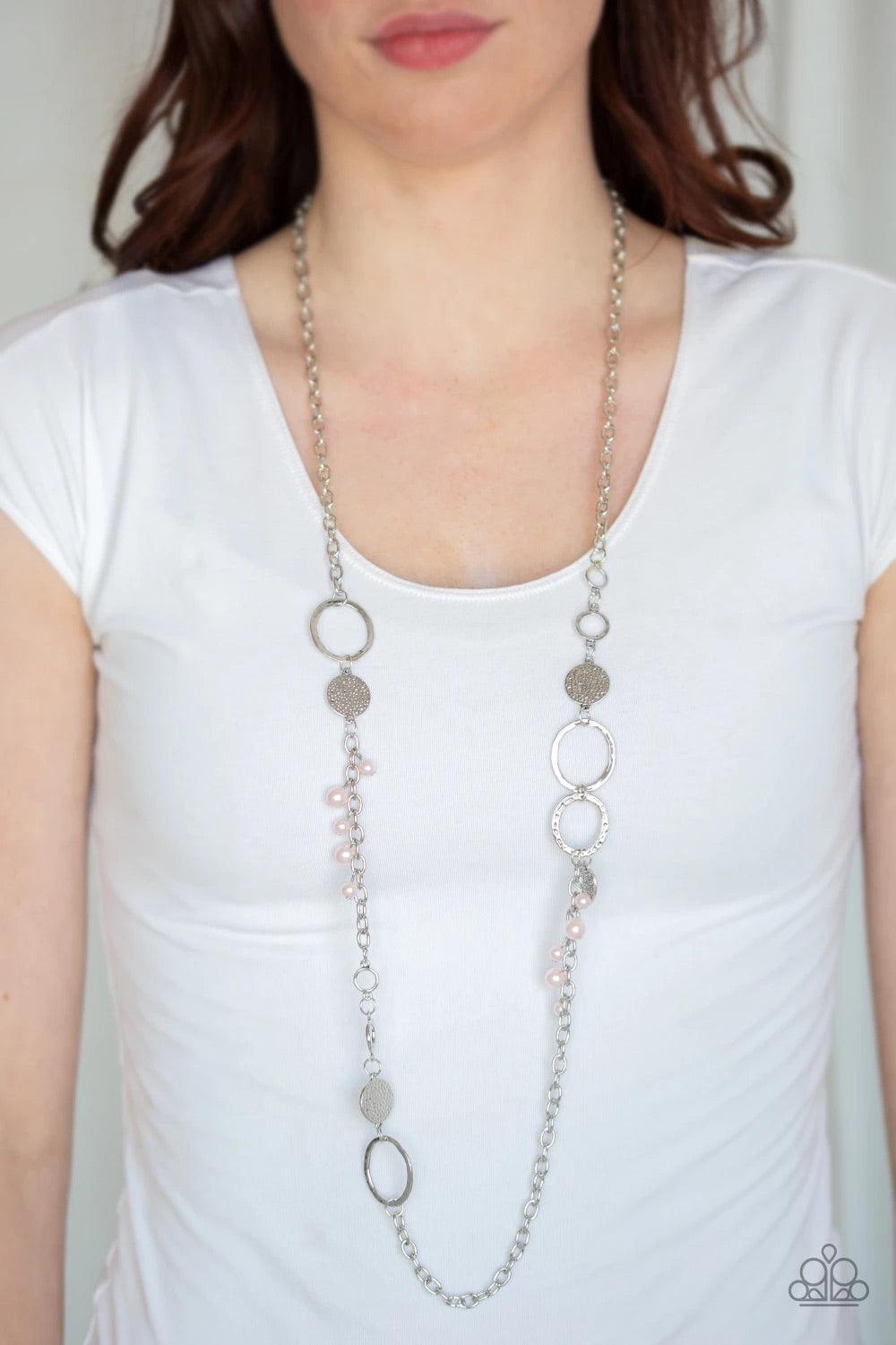 Paparazzi Accessories Unapologetic Flirt - Pink Infused with sections of shimmery silver chains, an assortment of hammered silver discs and silver rings link across the chest. A collection of pearly pink beads and dainty silver heart charms asymmetrically
