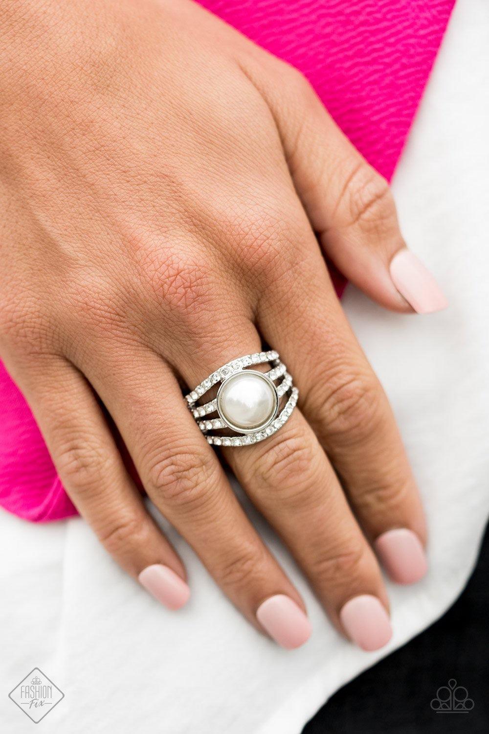 Paparazzi Accessories A Big Break - White Radiating with glassy white rhinestones, row after row of glittering silver bars arc across the finger. A pearly white bead is pressed into the center of the layered bands, adding a dramatically refined finish to
