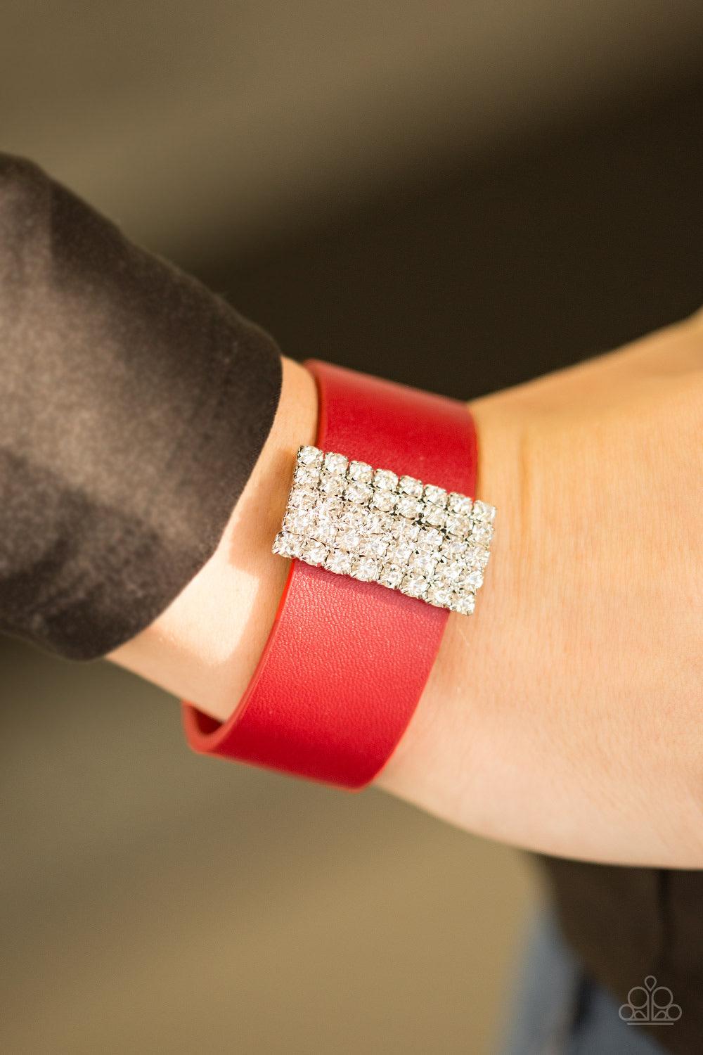 Paparazzi Accessories Walk The CATWALK ~Red Encrusted in glittery white rhinestones, a sparkling frame slides along a strip of red leather, creating a blinding centerpiece. Features an adjustable snap closure. Sold as one individual bracelet.