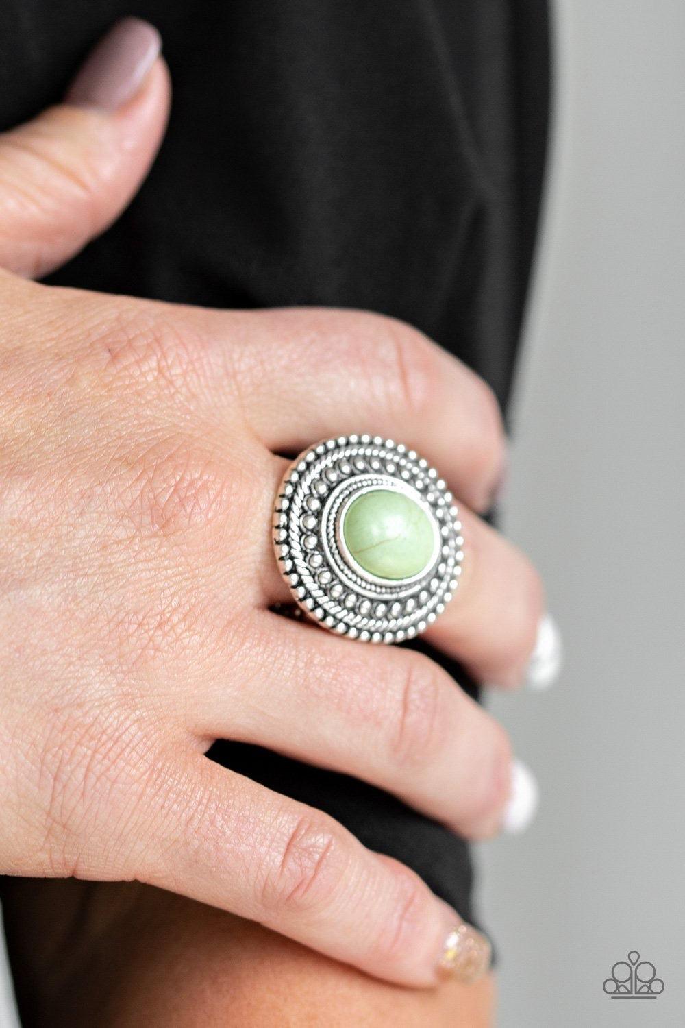 Paparazzi Accessories Terra Terrain - Green Chiseled into a tranquil oval, a refreshing green stone is pressed into the center of a shimmery silver frame spinning with studded patterns for a seasonal flair. Features a stretchy band for a flexible fit. Jew