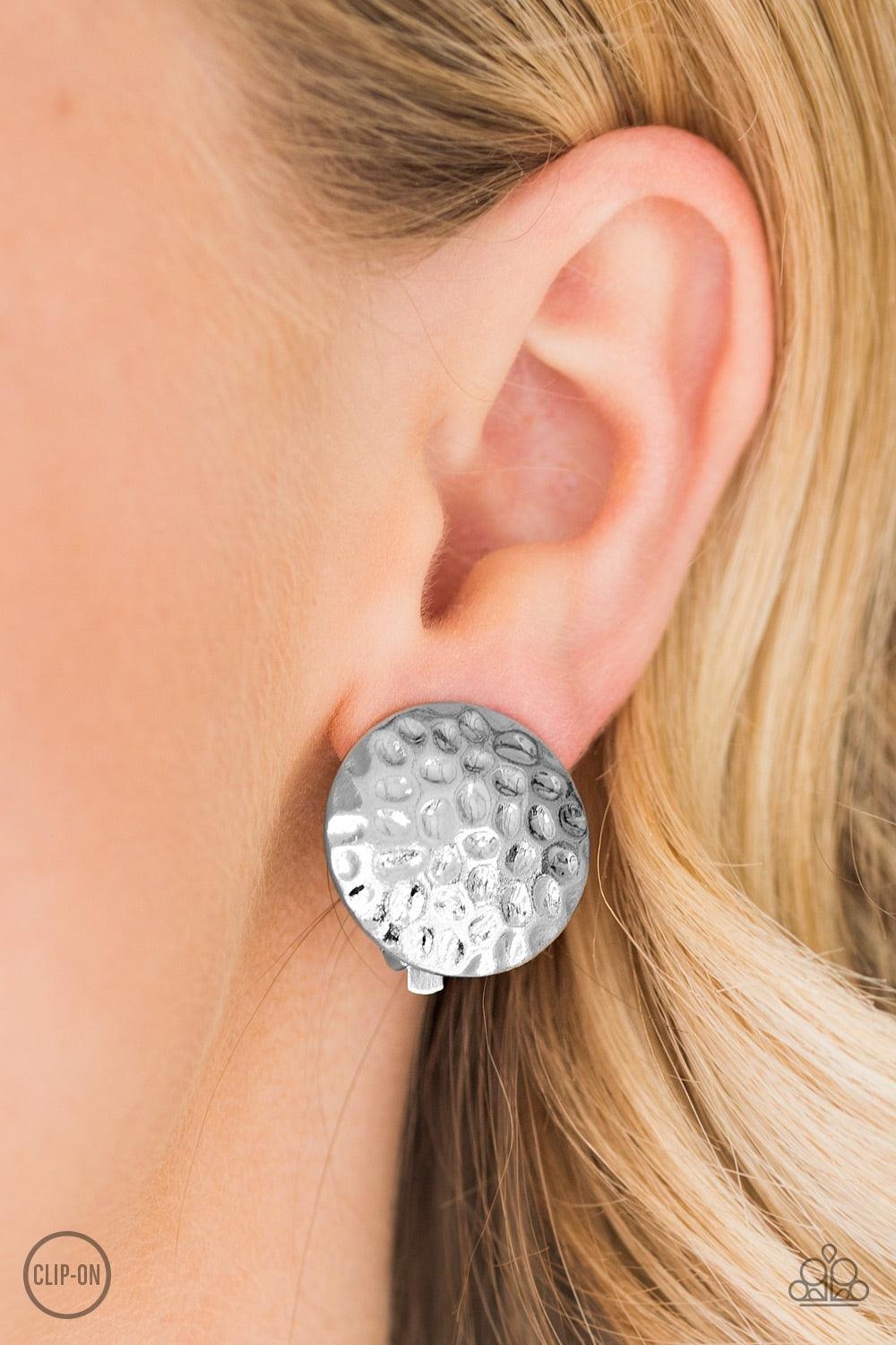 Paparazzi Accessories Hold The SHINE - Silver *Clip-On A round silver frame has been delicately hammered in glistening shimmer for a bold industrial look. Earring attaches to a standard clip-on fitting. Jewelry