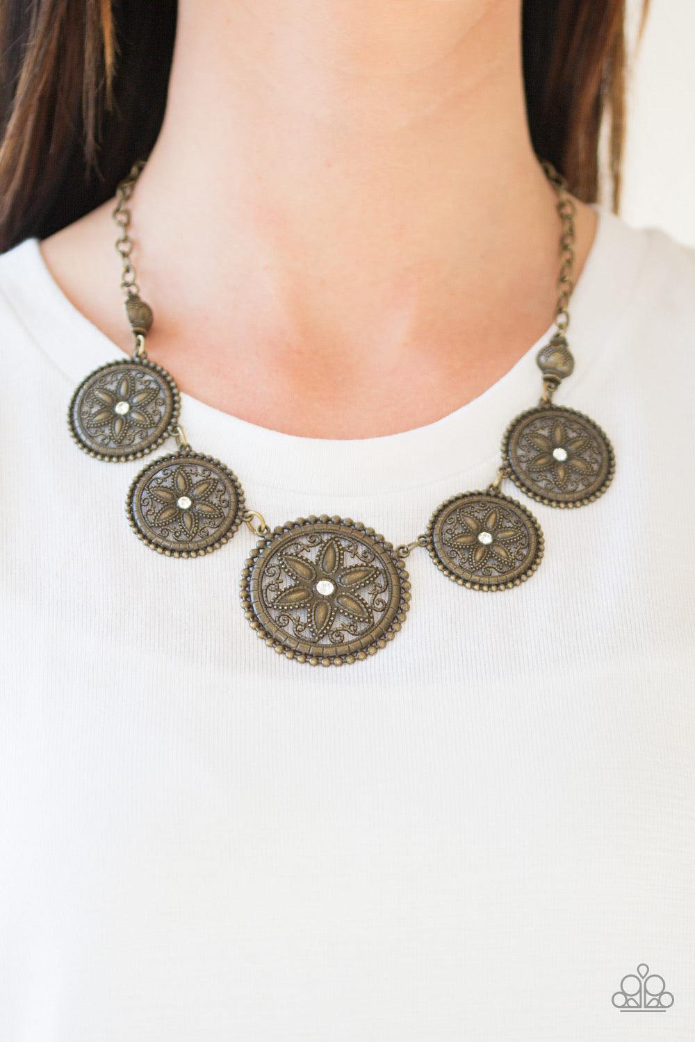 Paparazzi Accessories Written In The STAR LILLIES - Brass Dotted with glittery rhinestone centers, floral brass frames gradually increase in size as they link below the collar for a whimsical look. Features an adjustable clasp closure. Jewelry