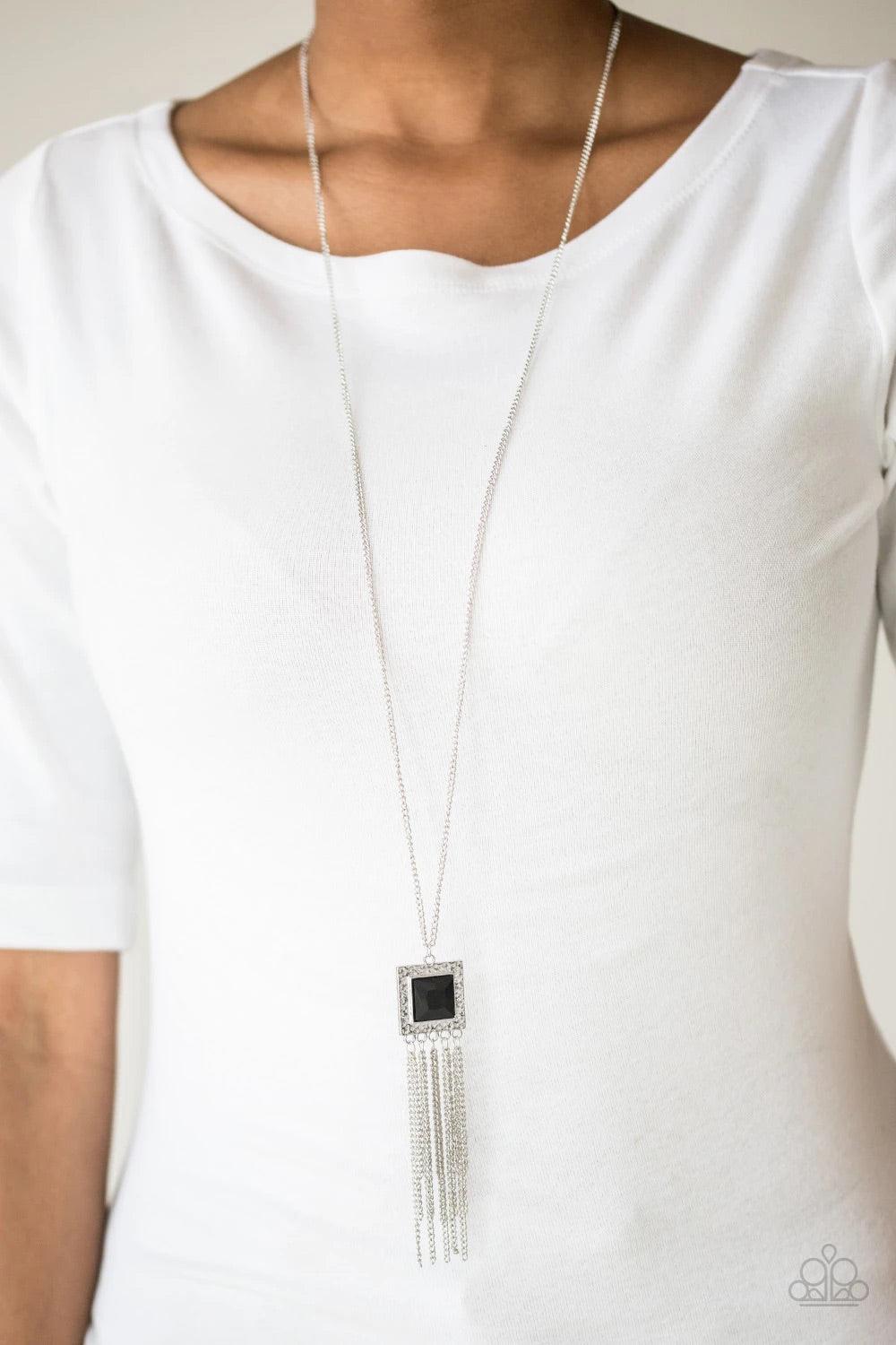 Paparazzi Accessories Shimmer Sensei - Black Swinging from the bottom of a lengthened silver chain, a delicately hammered square frame gives way to a shimmery silver fringe. Featuring a regal square cut, a glittery black gem is pressed into the center of