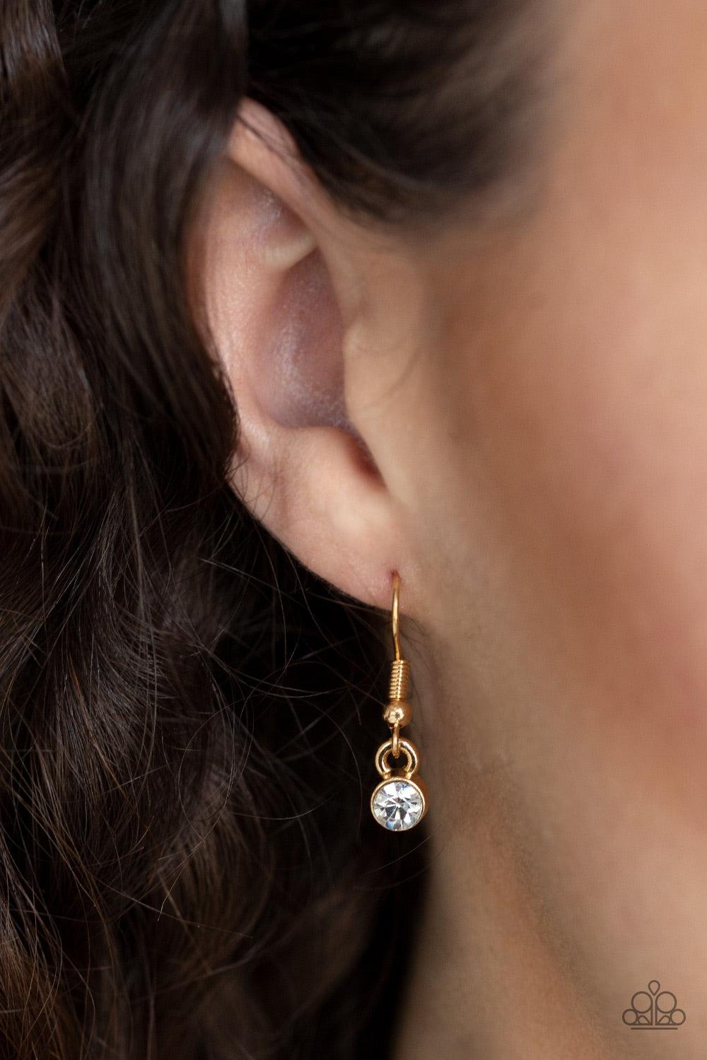 Paparazzi Accessories Five-Star Starlet - Gold Encased in sleek gold frames, a collection of glittery white rhinestones coalesce into dazzling frames below the collar. Matching rhinestones trickle from the center, creating a glamorous extended pendant. Fe