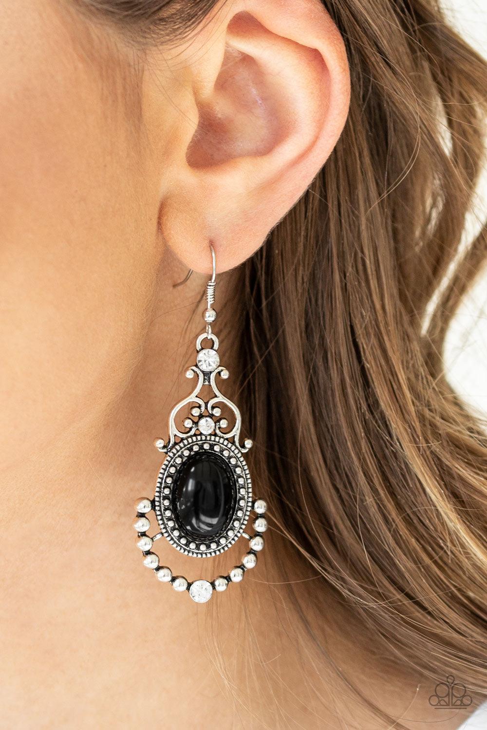 Paparazzi Accessories CAMEO And Juliet ~Black A shiny black bead is pressed into an ornate silver frame swirling with frilly silver filigree and shiny silver studs. Glassy white rhinestones sporadically dot the frame for a sparkling finish. Earring attach