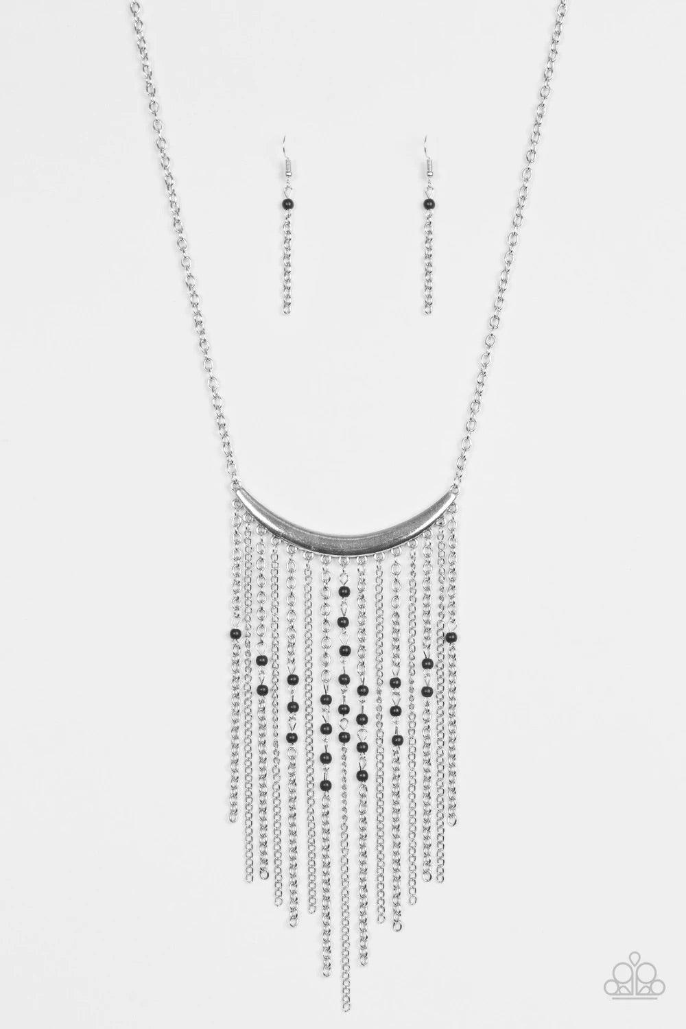 Paparazzi Accessories Runaway Rumba - Black Glistening silver chains stream from the bottom of a shiny silver crescent, creating a bold tapered fringe down the chest. Dainty black stone beads sporadically trickle down the chains for a seasonal finish. Fea