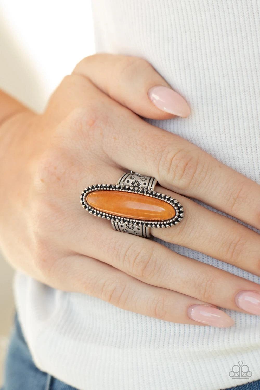 Paparazzi Accessories Ultra Luminary - Orange An oblong orange stone adorns the center of a studded silver frame that sits atop a thick silver band stamped in antiqued stars. Features a stretchy band for a flexible fit. Sold as one individual ring. Jewelr