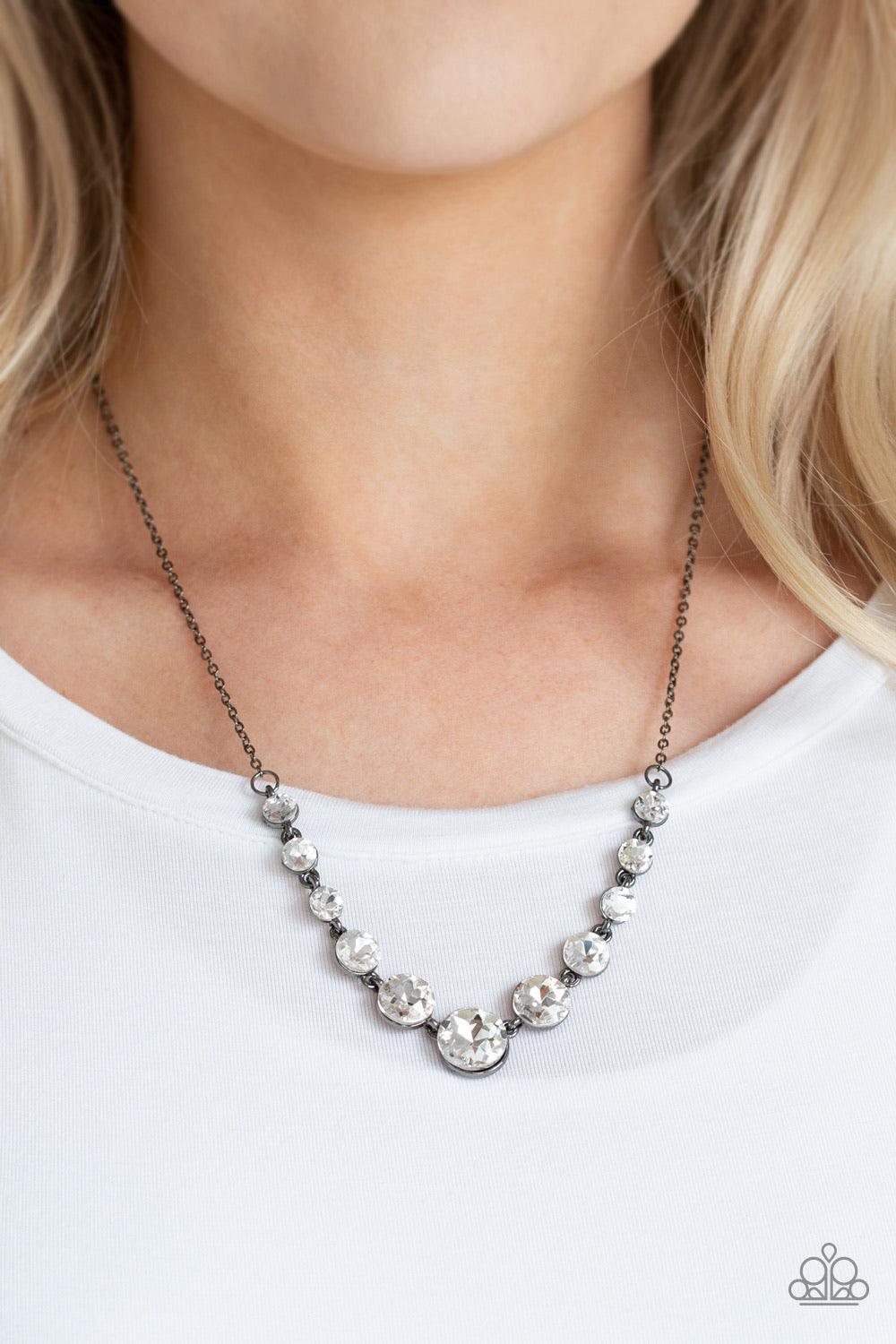 Paparazzi Accessories Leading Socialite - Black Gradually increasing in size near the center, a collection of glassy white rhinestones links below the collar for a timeless look. Features an adjustable clasp closure. Sold as one individual necklace. Inclu