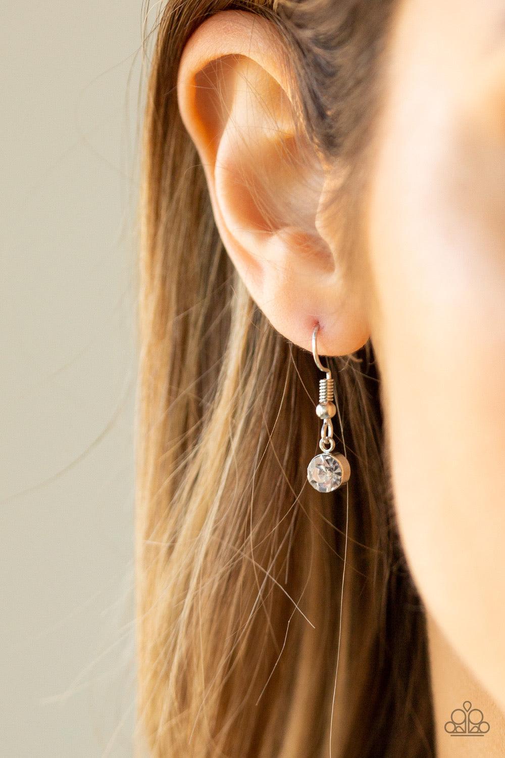 Paparazzi Accessories Spellbound - Brown An oversized teardrop gem is nestled inside of an abstract silver frame that has been dipped in glassy white rhinestones. The spellbinding pendant swings from the bottom of a lengthened silver chain for a glamorous