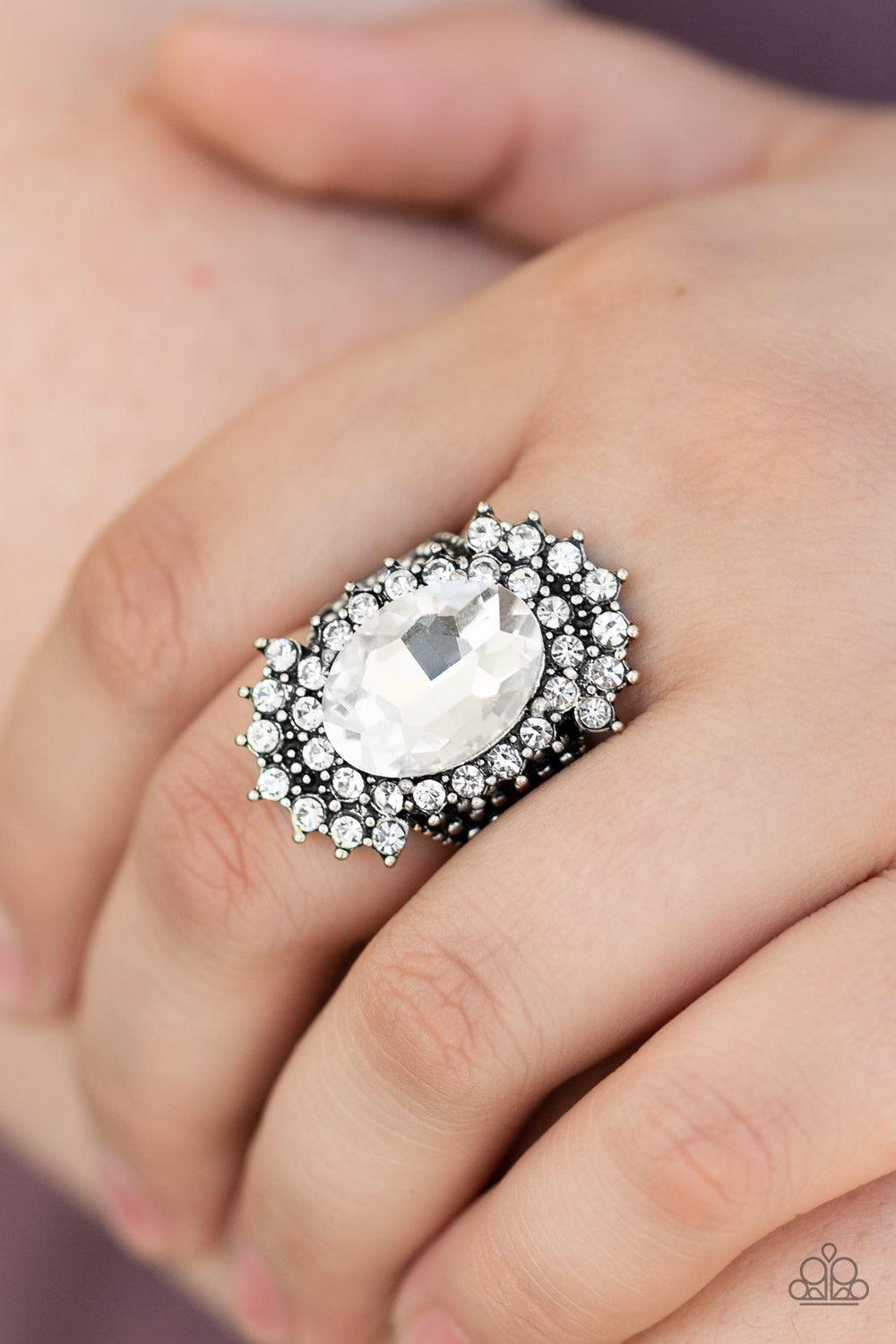 Paparazzi Accessories Him And HEIR - White Glittery white rhinestones flare out from a dramatically oversized white rhinestone center. The regal frame sits atop a silver studded band for a statement-making finish. Features a stretchy band for a flexible f