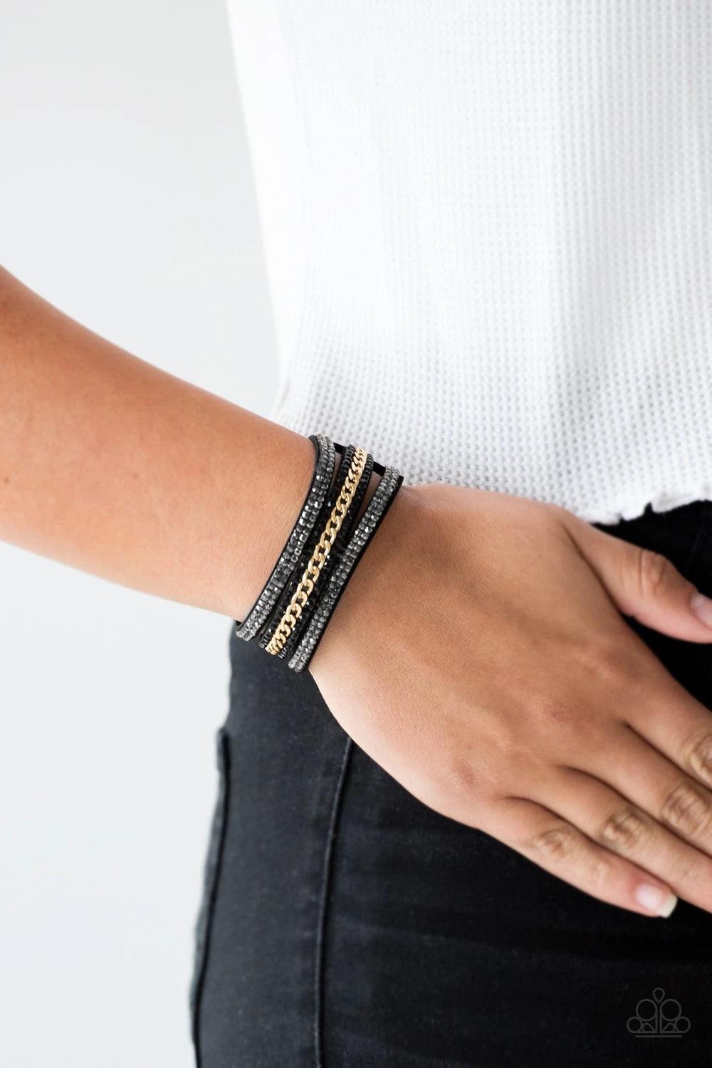 Paparazzi Accessories Rollin’ in Rhinestones - Black Rows of glassy hematite and black rhinestones and a shimmery gold chain are encrusted along black suede bands for a sassy look. Features an adjustable snap closure. Sold as one individual bracelet. Jewe