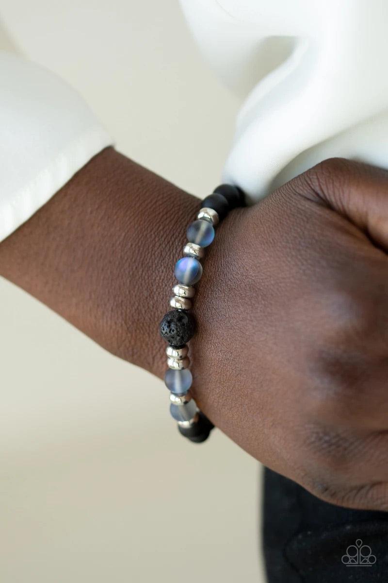 Paparazzi Accessories Grace - Blue Infused with dainty silver beads, a collection of black stone beads, black lava rock beads, and glassy iridescent beads are threaded along a stretchy band around the wrist for a seasonal flair. Sold as one individual bra