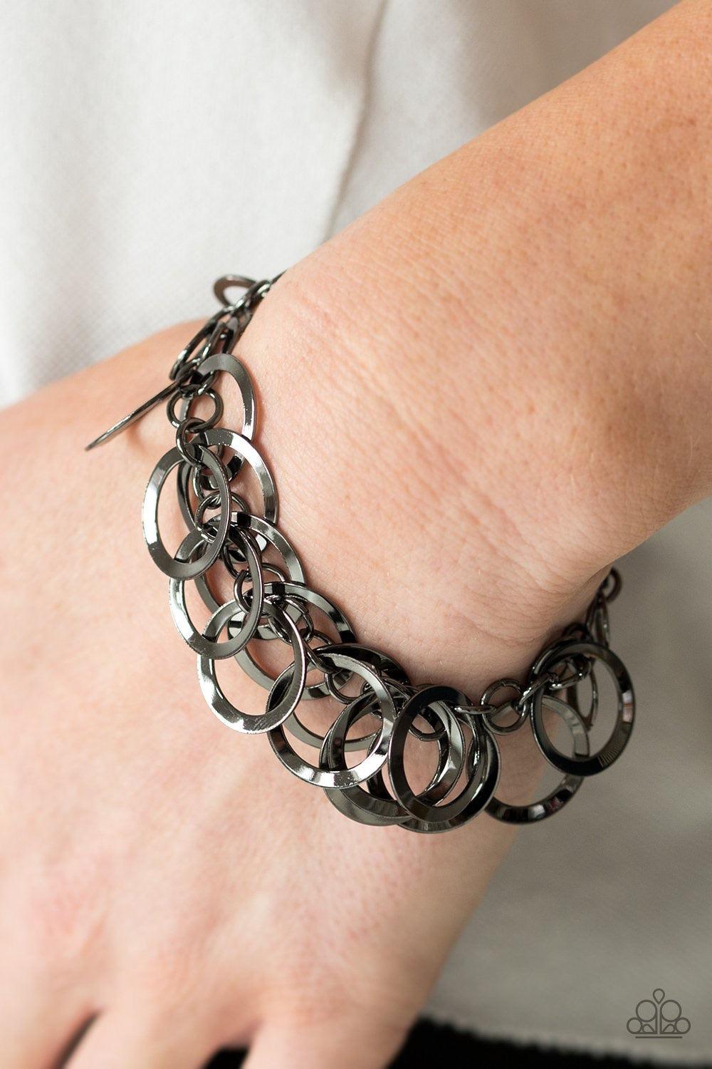 Paparazzi Accessories Circus Cabaret - Black Glistening gunmetal hoops swing from a bold gunmetal chain, creating a flirty fringe around the wrist. Features an adjustable clasp closure. Sold as one individual bracelet. Jewelry